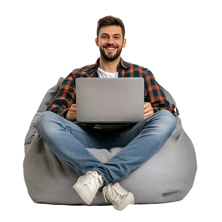 A client comfortably learning remotely on a laptop, showcasing Indosoft Inc.'s flexible, high-impact remote training designed for productivity and growth. Client engaging in remote training using a laptop while seated on a bean bag, representing Indosoft Inc.’s flexible remote learning environment