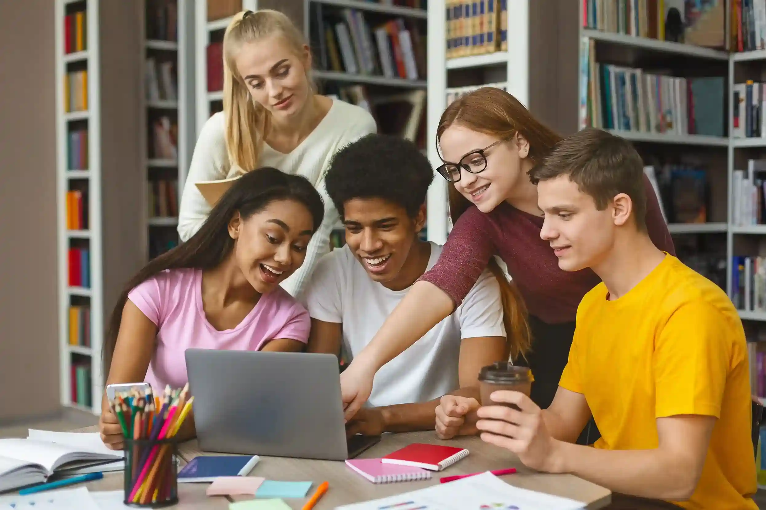 College students accessing Indosoft’s education system on a laptop to simplify academic inquiries and improve service delivery. Group of college students using a laptop with Indosoft’s education solutions to connect seamlessly with professors and automate campus communication.