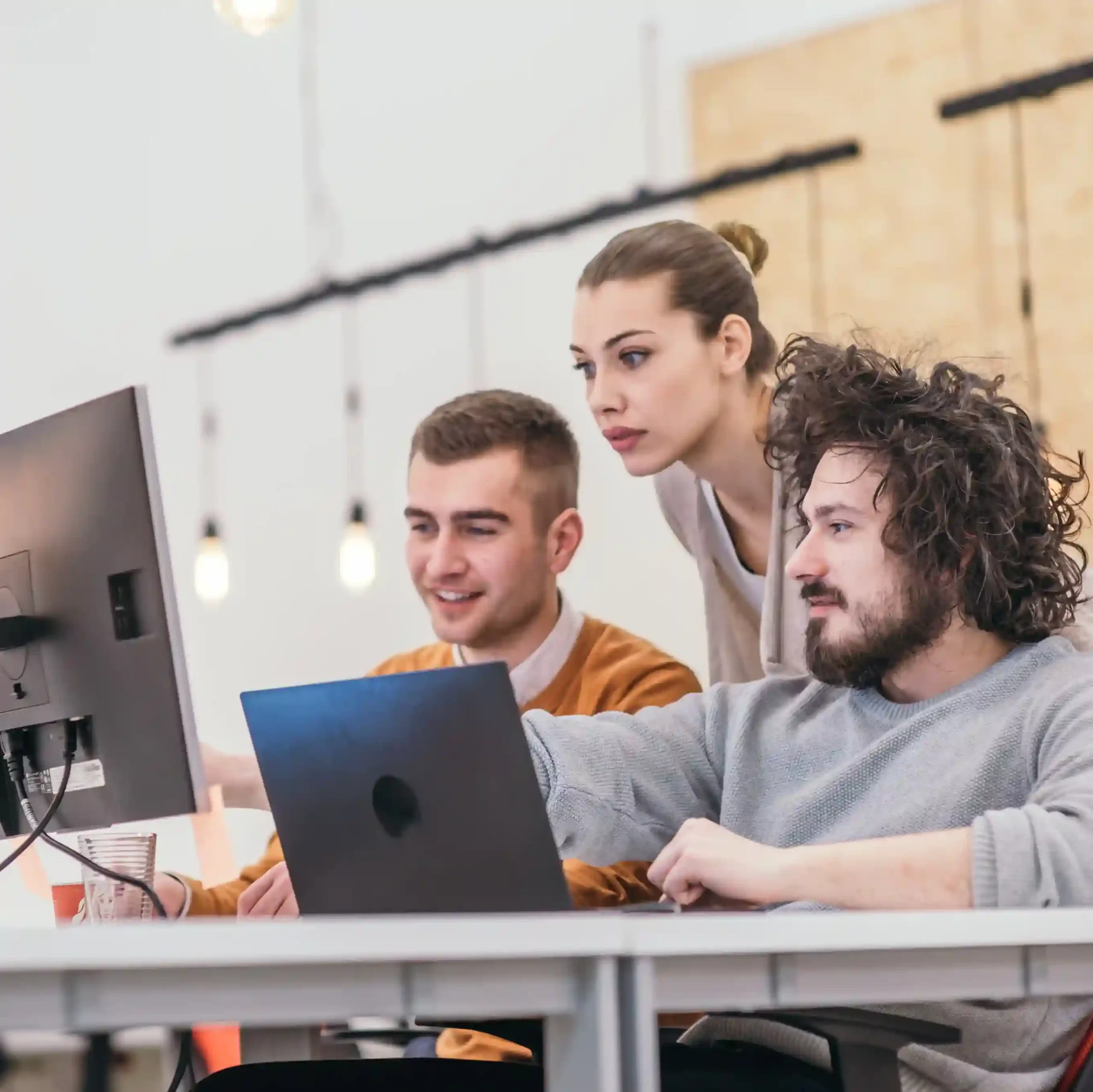 Startup team focused on solving challenges together, representing innovation and growth powered by Indosoft’s technology. Startup team collaborating around a computer, brainstorming solutions with Indosoft’s AI-powered communication tools.