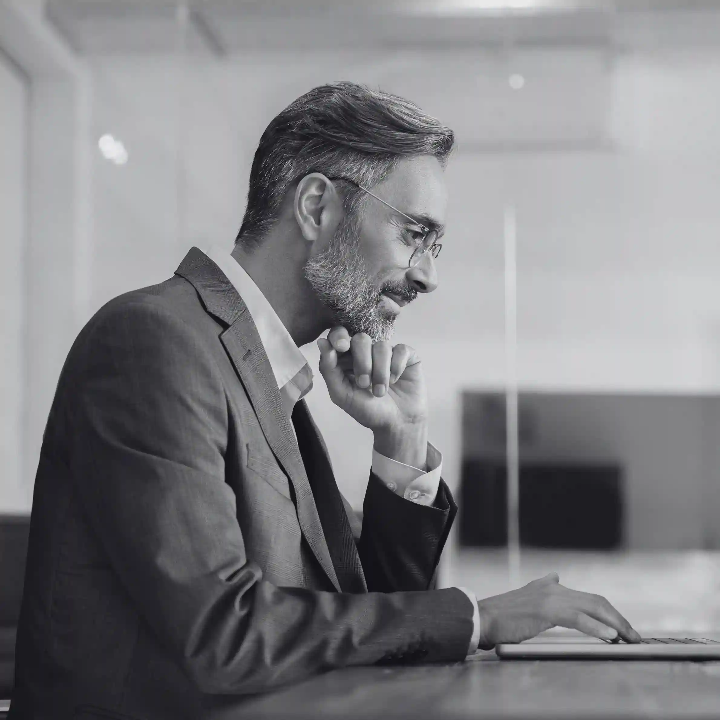 The professional’s engaged posture symbolizes how Indosoft empowers organizations with smarter routing, deeper automation, and stronger architectural stability than RingOver. Business professional working thoughtfully at a computer, representing Indosoft’s stronger automation and routing capabilities compared to RingOver.