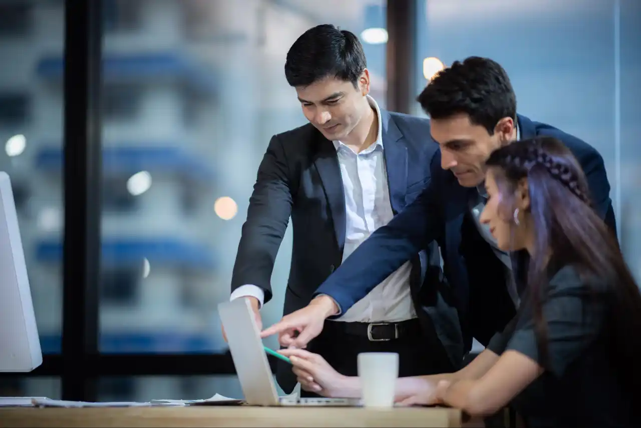 Team of enterprise professionals discussing workflow improvements using insights from Indosoft’s automation platform. Enterprise employees collaborating around a laptop while using Indosoft’s platform to address a complex operational challenge.