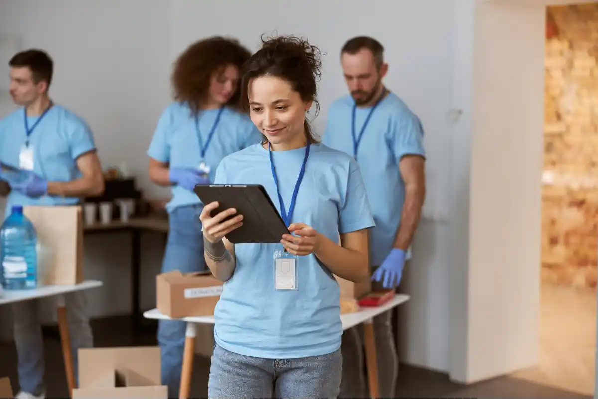 Nonprofit team member checking updates on a tablet integrated with Indosoft’s mission-driven communication solutions. A nonprofit volunteer using a tablet to coordinate team activities through Indosoft’s unified communication platform.