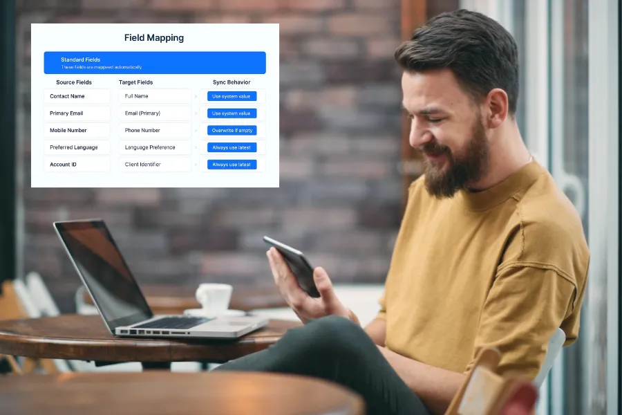 A user sitting in a café with Indosoft’s automated field-mapping interface shown on screen. Man using his phone beside an Indosoft interface showing smart field mapping automation.