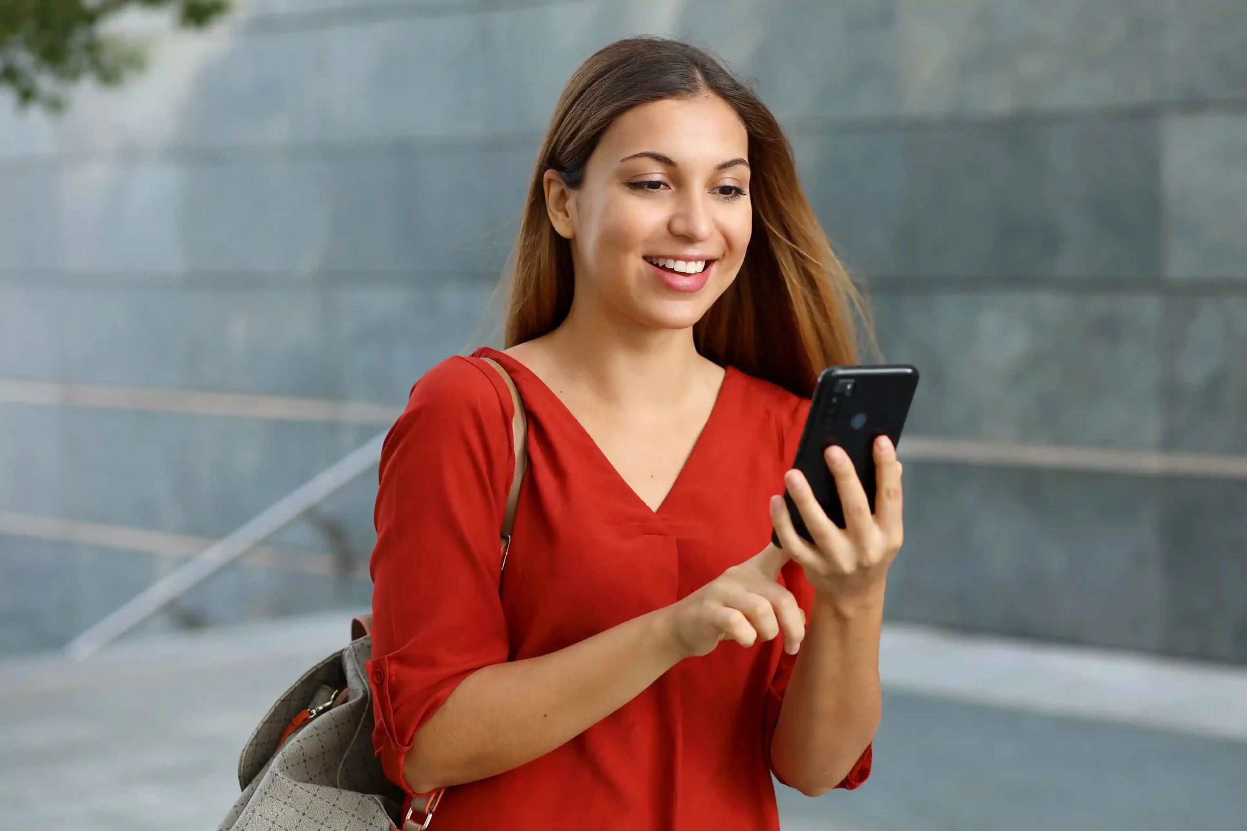 While reviewing messages on her phone, a customer benefits from SMS targeting that reflects updated profile details and recent interactions. A professional checks her phone while on the move, engaging with SMS communications that adjust automatically as her preferences and activity change.