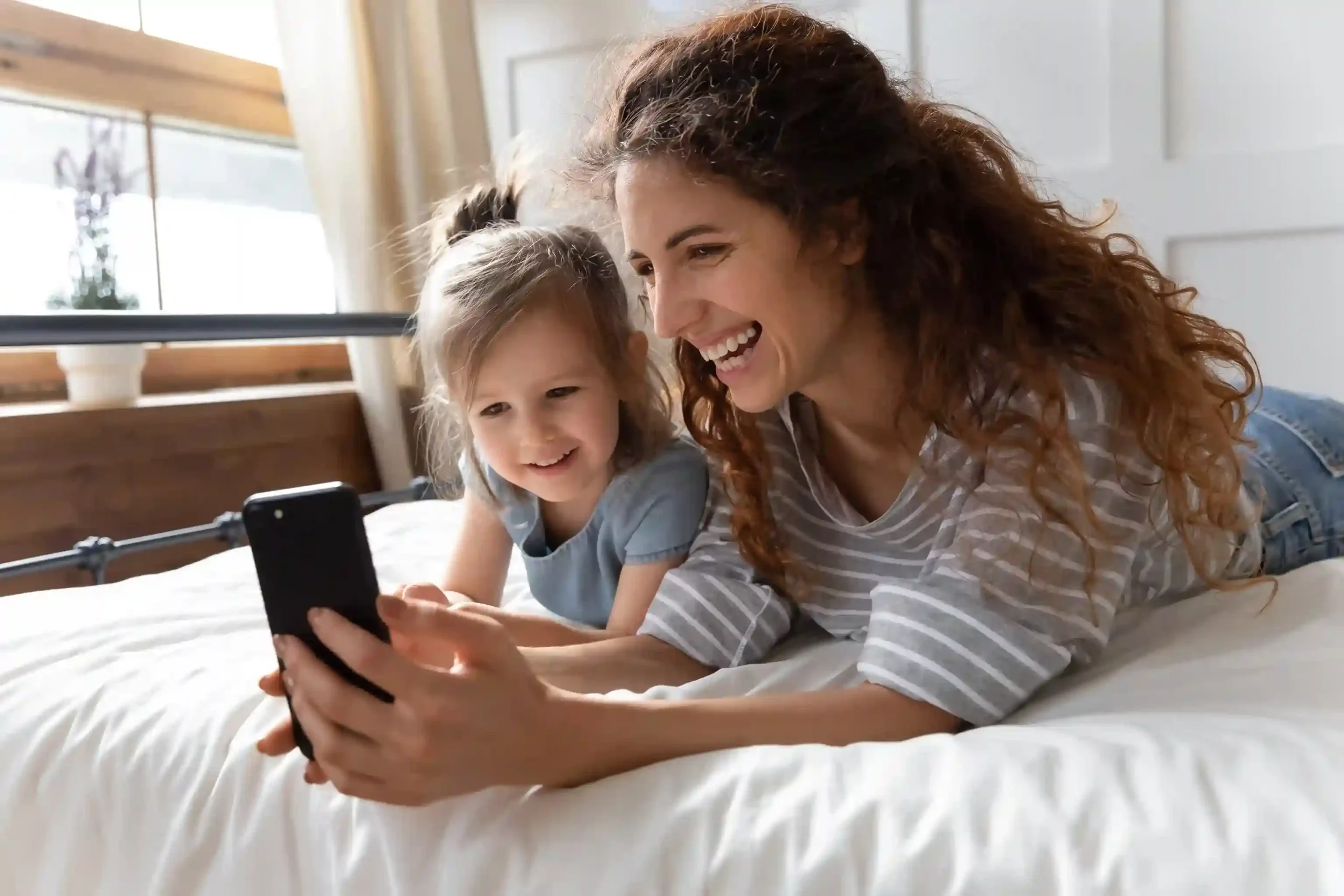 A mother reviews her phone comfortably, knowing Indosoft call masking protects her number while call activity remains fully documented. A mother smiles while using her phone at home, confident that Indosoft call masking keeps her real number hidden while maintaining secure call records.