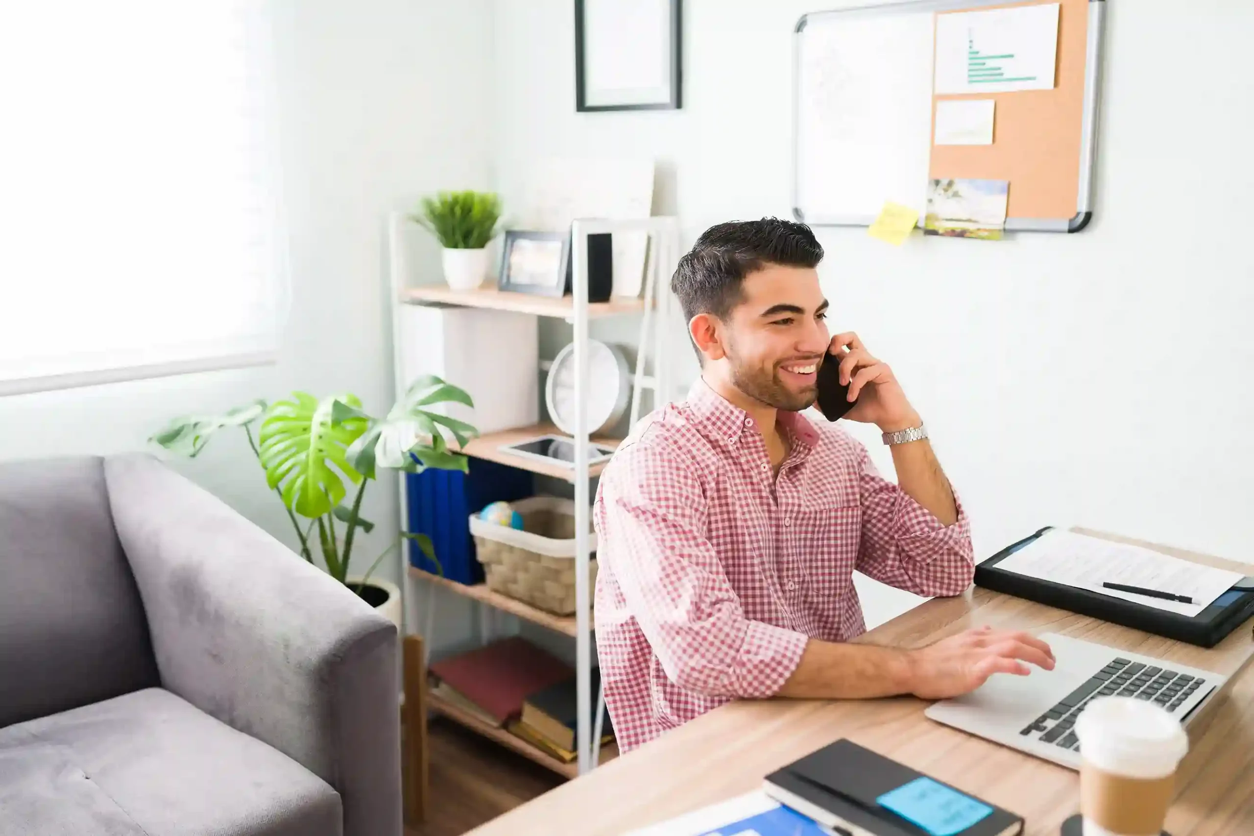 An agent talks on the phone while follow-up actions are automatically triggered through workflow automation. A remote agent on a phone call uses a laptop as automated workflows trigger follow-up actions in the background.