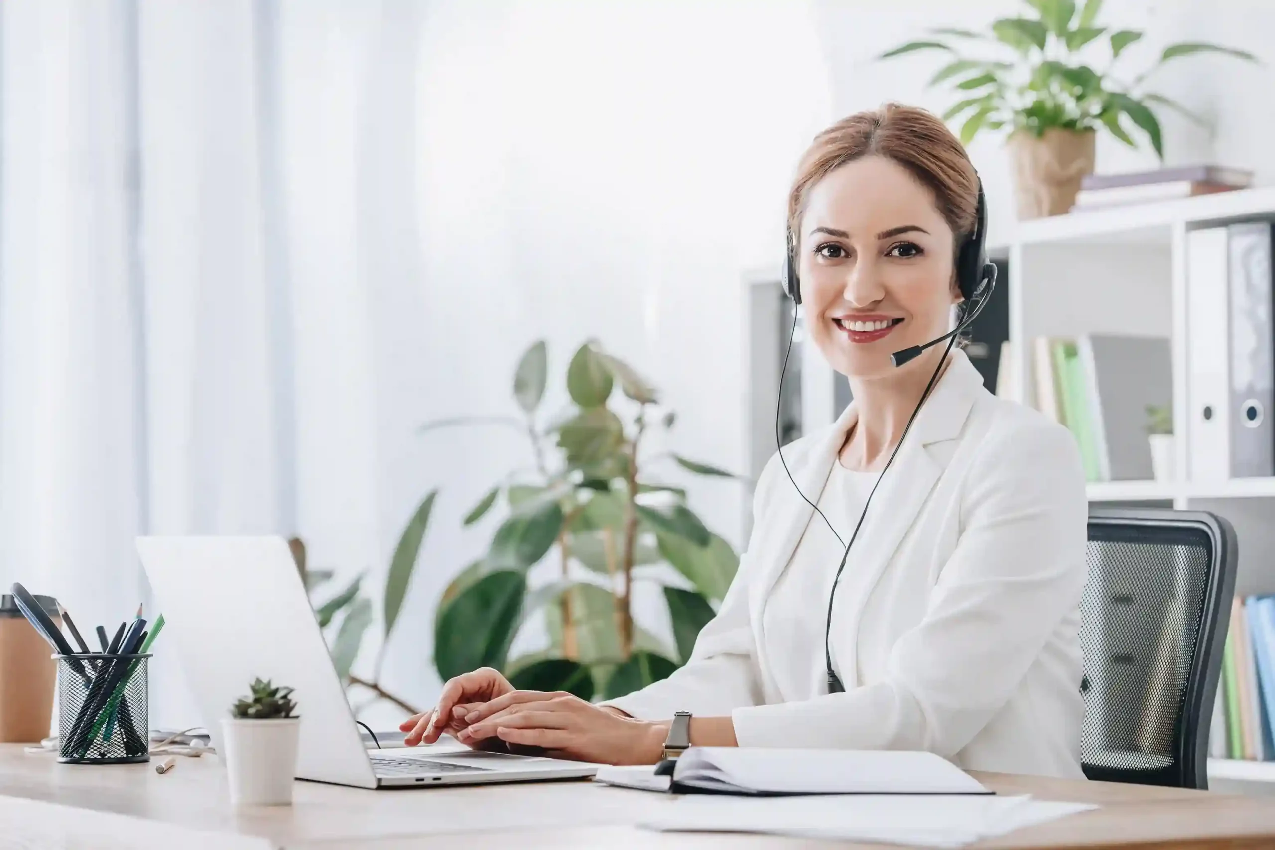 An agent works comfortably at her desk with a headset on, managing calls within defined availability windows that support healthier work patterns and consistent service. An agent works comfortably at her desk with a headset on, managing calls within defined availability windows that support healthier work patterns and consistent service.