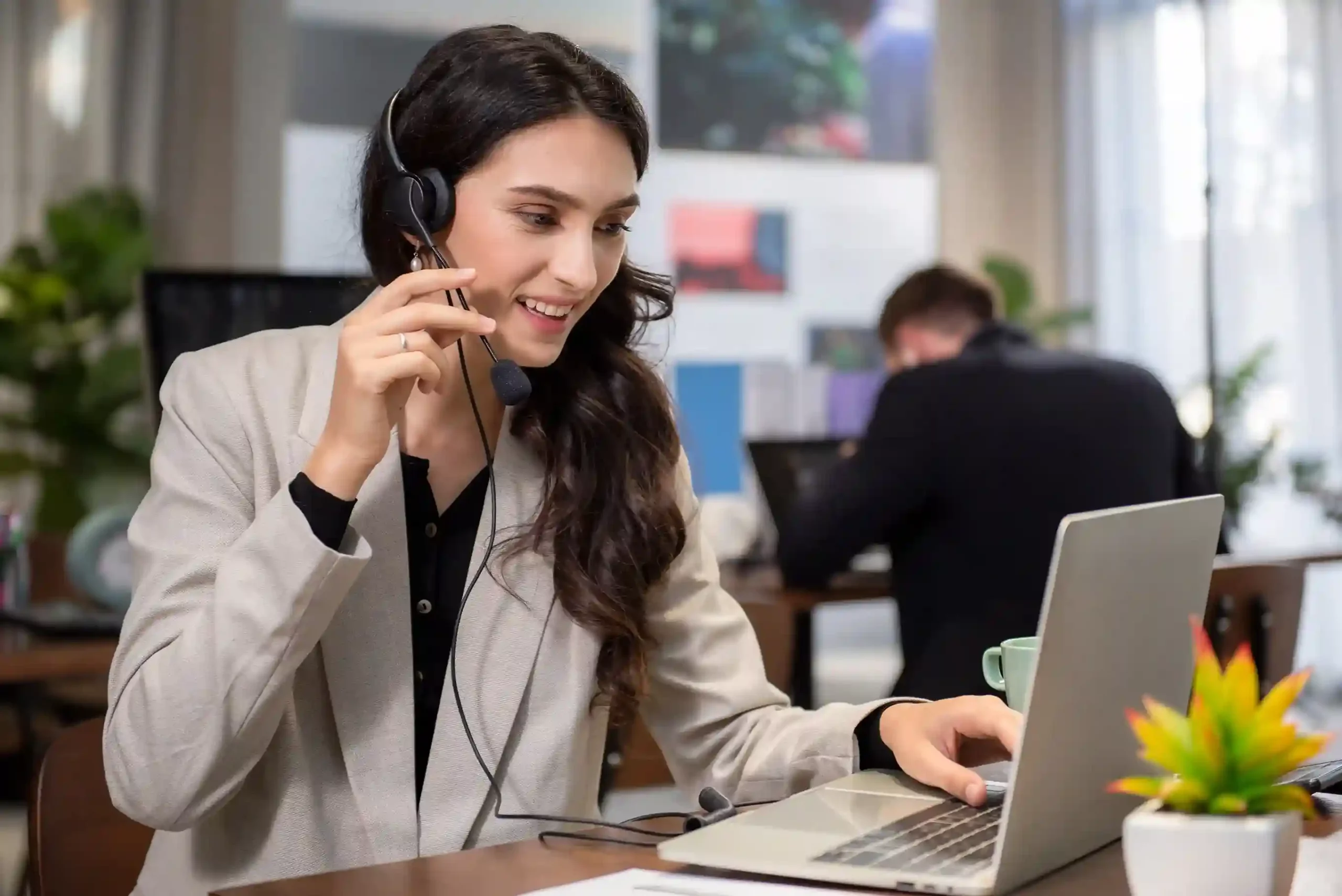 An agent on a headset reviews call outcomes on a laptop to support reporting and performance analysis through disposition tracking. A contact center agent uses a headset and laptop to log call dispositions that feed into detailed reporting and performance insights.