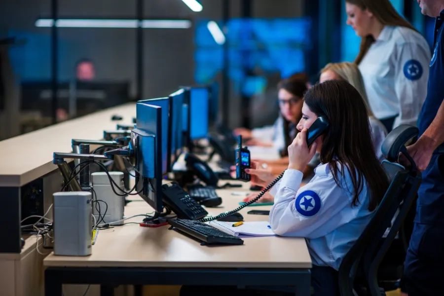 Retail entrepreneur consulting Indosoft on a tablet about callback bottlenecks and optimized routing during busy periods. Emergency dispatch operators handling calls in a control room, representing after-hours and overflow call routing.