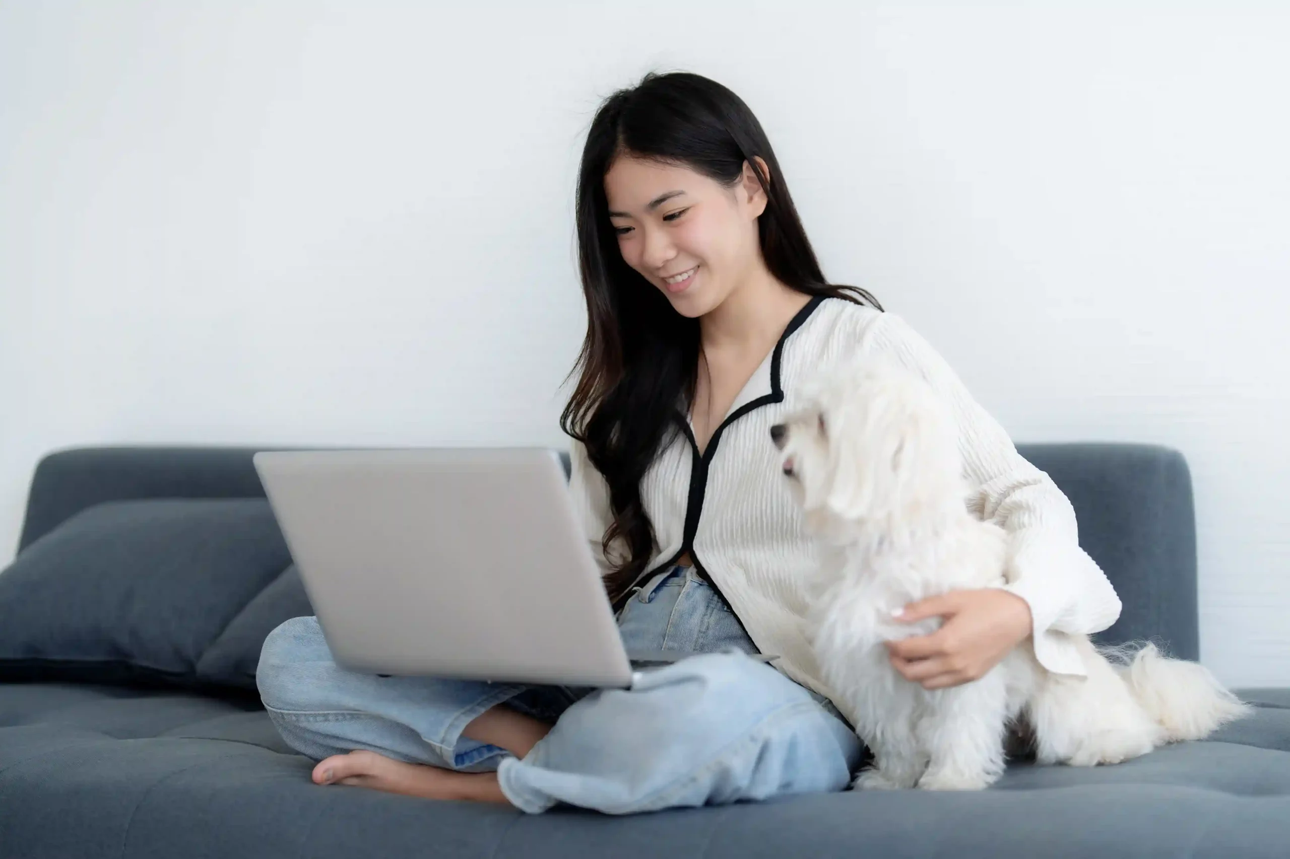 While speaking on a call, a user comfortably types notes on her laptop, keeping track of commitments and next steps in a relaxed home environment. A professional relaxes at home with her laptop, calmly capturing important call details in real time while continuing a live conversation without missing a beat.