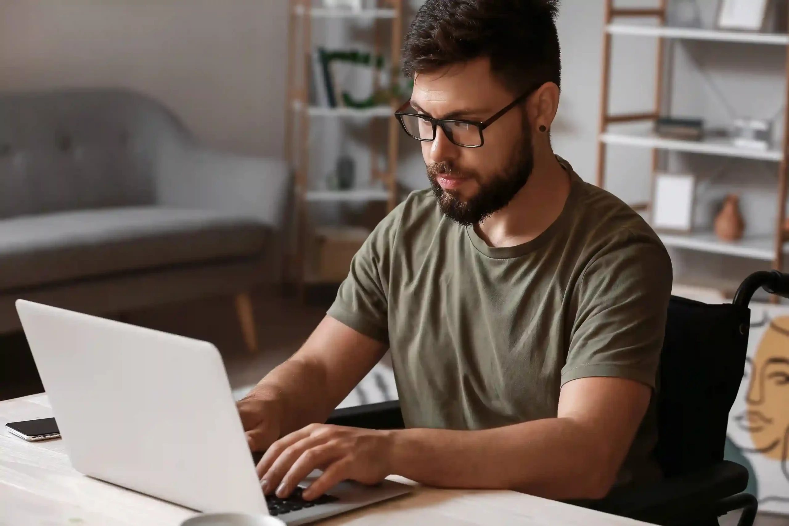 A professional focuses on his laptop while reviewing voicemail details in an email, using Indosoft to identify who called and when without opening another system An employee reviews a voicemail email on his laptop, quickly scanning the caller number and timestamp to understand the call context before responding through Indosoft