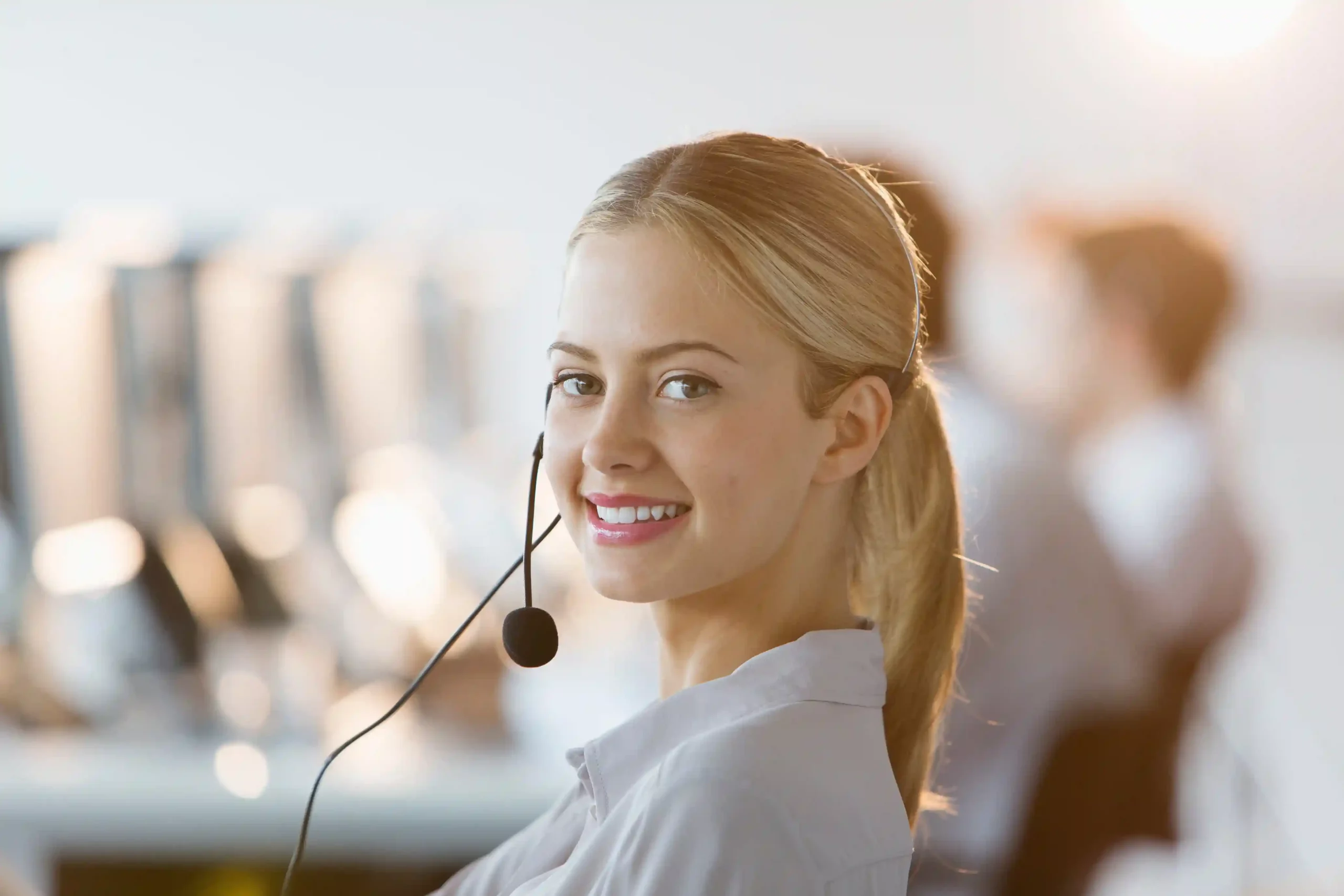 A customer service agent supporting high-volume messaging with reliable carrier-grade delivery systems. A contact center professional wearing a headset ensures reliable message delivery through enterprise-grade messaging infrastructure.