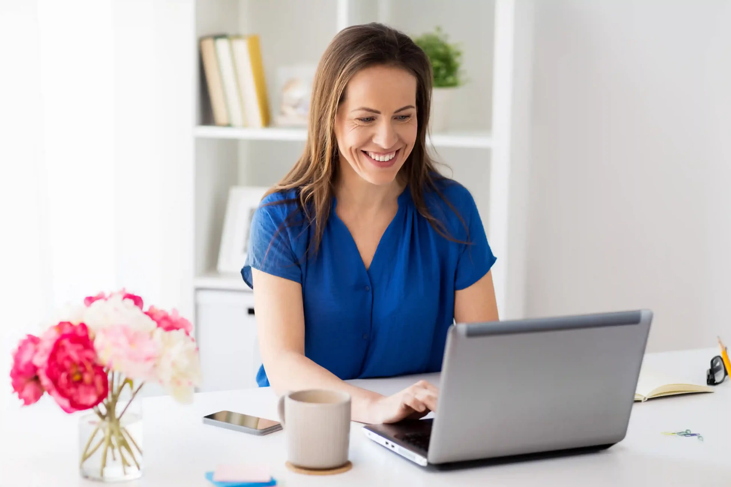 A professional works at a desk, smiling as she updates customer notes on her laptop, knowing all past interactions are organized and easy to find. A team member reviews customer details on a laptop, confidently preparing for the next conversation by accessing a complete contact history in one place.