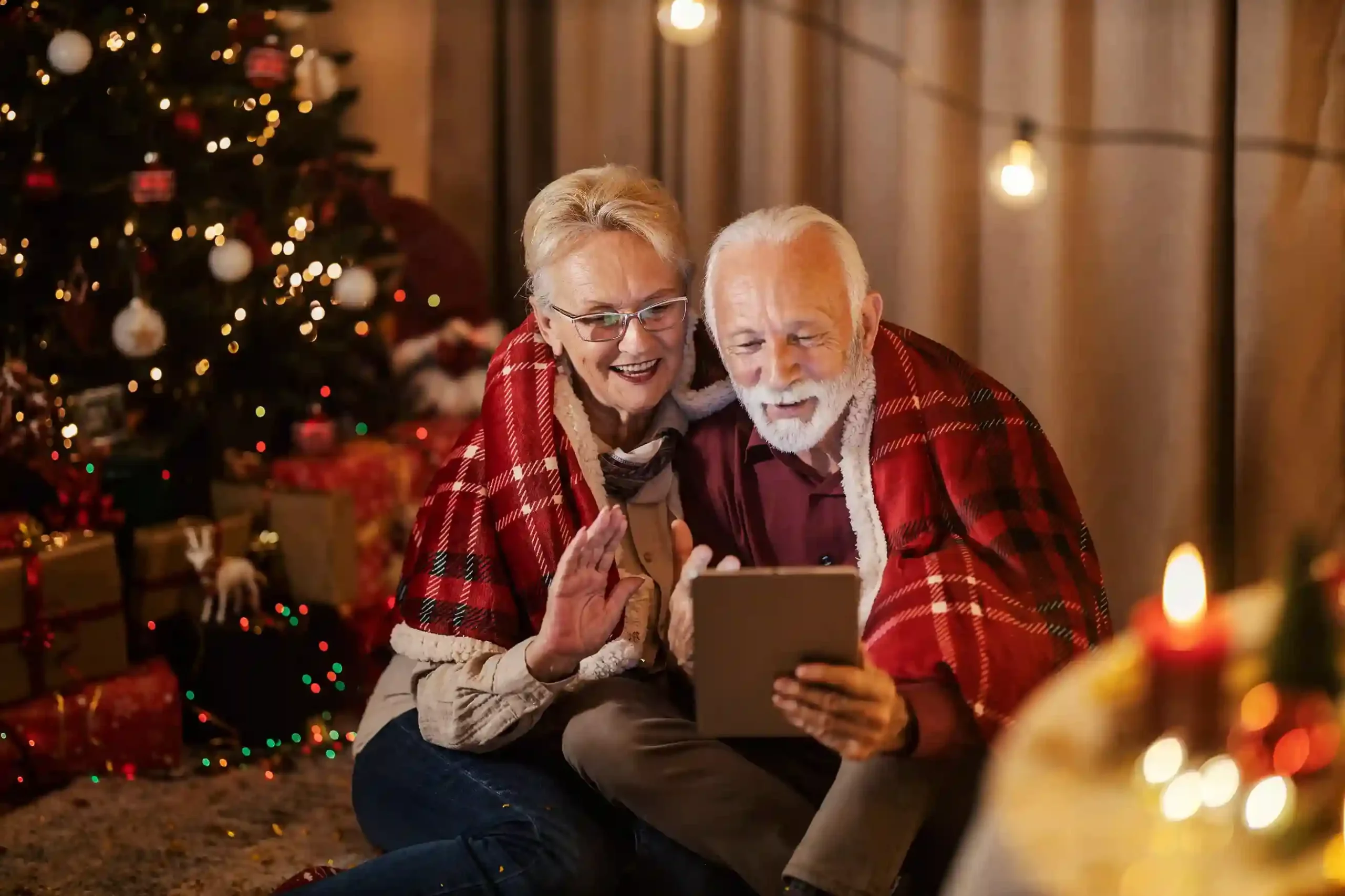 Two customers comfortably follow along on a screen while a greeting message clearly explains what will happen next, reducing uncertainty before speaking with an agent. A couple sits together reviewing information on a tablet, feeling reassured as a clear greeting explains wait times and next steps before their call continues.