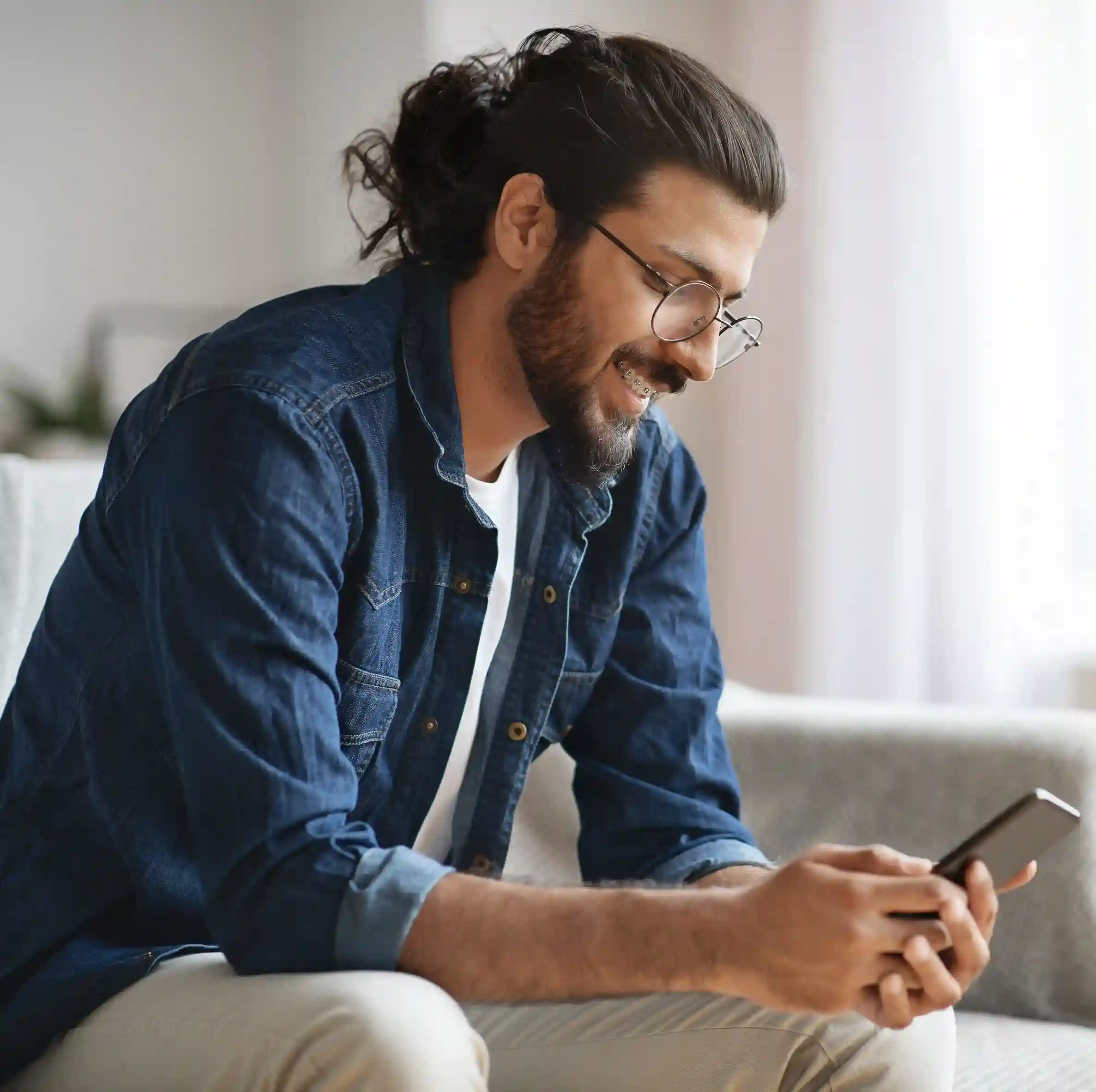 Professional support representative available to discuss Indosoft’s Automatic Callback benefits. Person using a mobile device as Indosoft accelerates outreach with streamlined bulk contact onboarding.