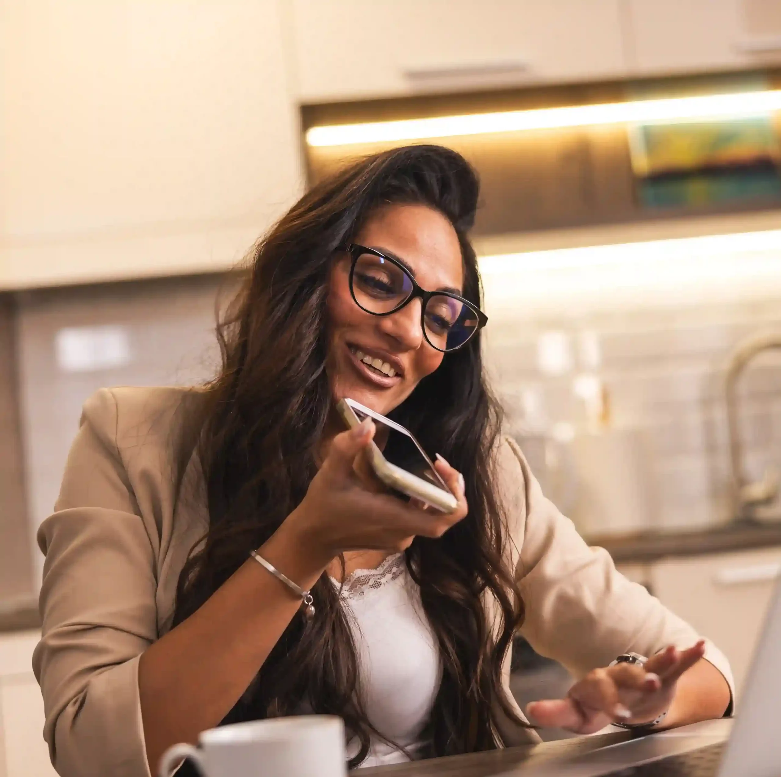 A business owner balances a customer call and on-screen tasks, relying on international numbers to engage with global clients from a single workspace. A professional speaks confidently into her phone while reviewing work on her laptop, using international numbers to stay connected with customers across multiple countries.
