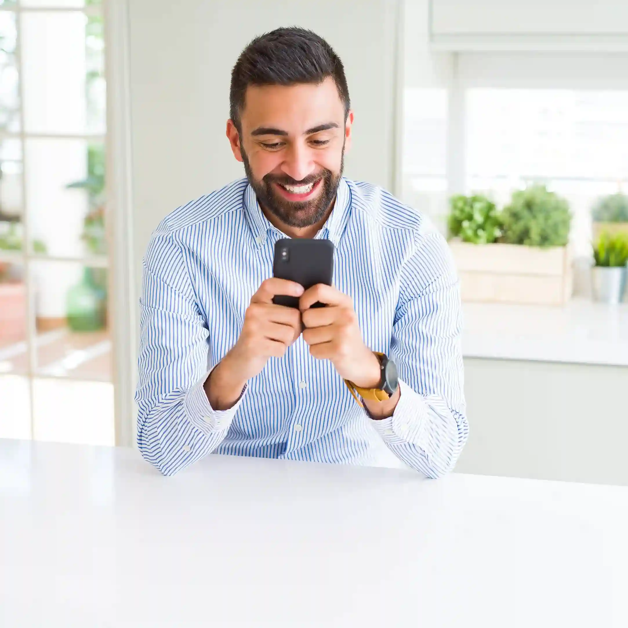 A caller confidently navigates options on his phone, reflecting how IVR simplifies inbound call management by directing requests efficiently from the beginning. A customer smiles while using his phone at home, experiencing a smooth IVR interaction that guides his inbound call clearly from the very first step.