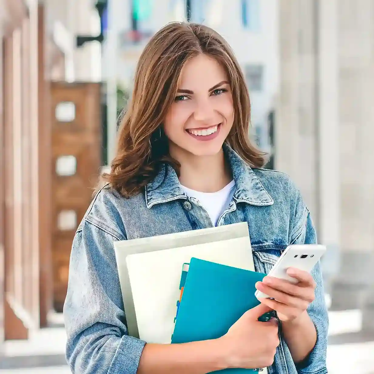 Walking through the office with files in hand, an employee reviews contacts on her phone, showing how Indosoft balances shared access with private contact protection. Smiling while checking her phone and holding work documents, a team member confidently manages contact access, reflecting how Indosoft keeps shared and private contacts clearly separated.