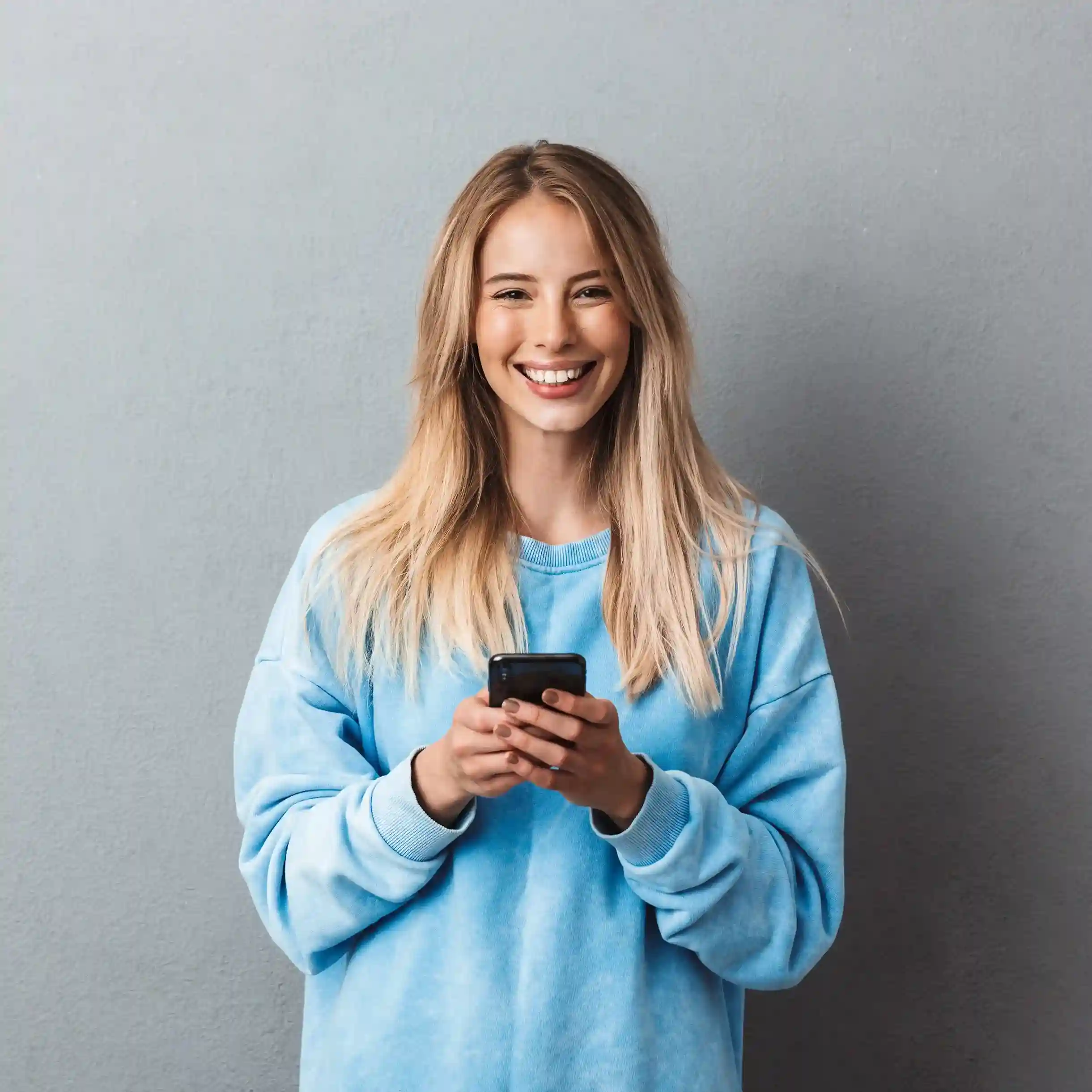 A user checks her phone with ease, reflecting how SMS filters simplify message handling and remove unnecessary distractions. A professional smiles while reviewing a message on her phone, confident that SMS filtering keeps communication clear and easy to manage.