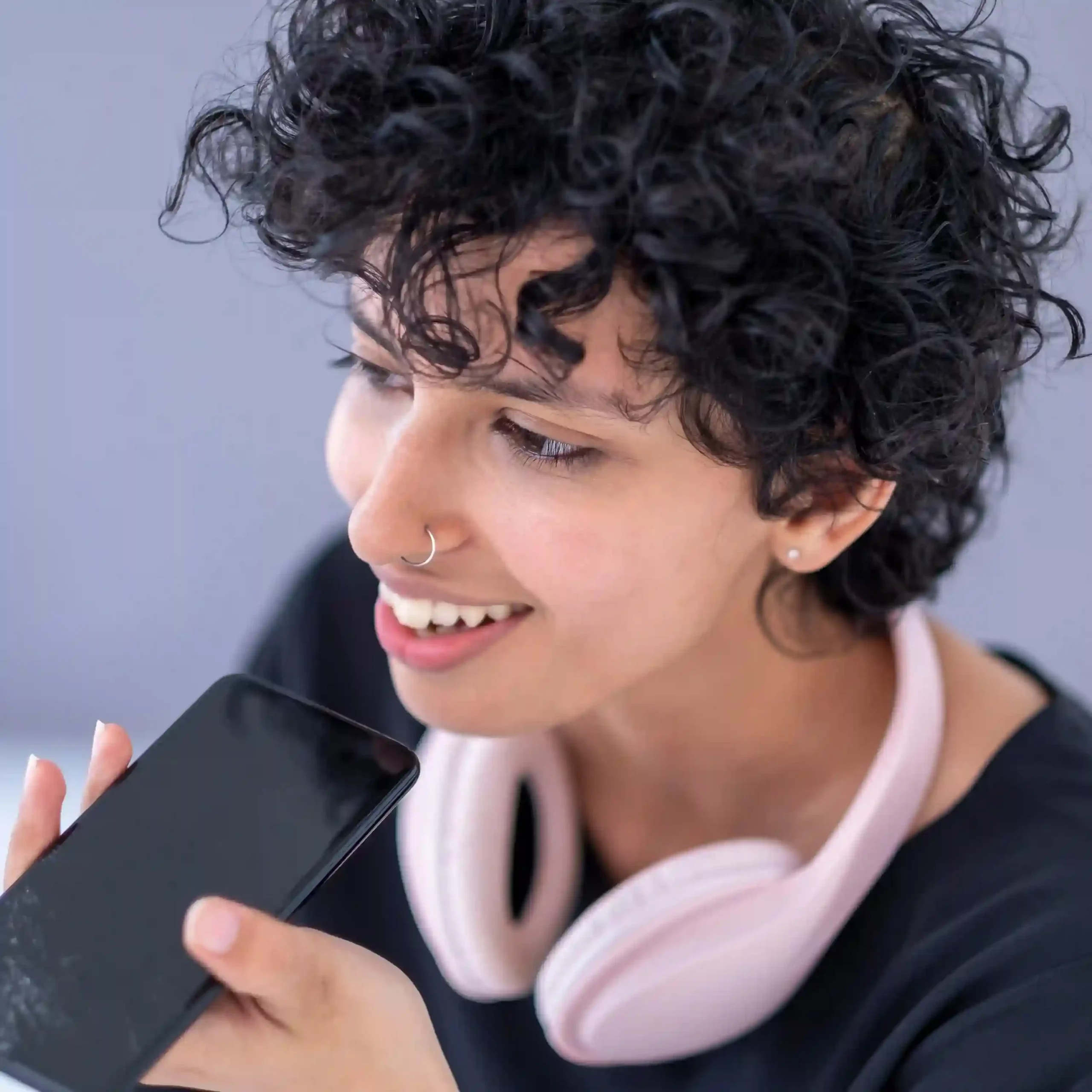 An agent records a voicemail message on her phone, ensuring the customer conversation continues even when live calls cannot be answered. A contact center user speaks into her phone with confidence, continuing a customer conversation through voicemail so no request is lost when a call is missed.