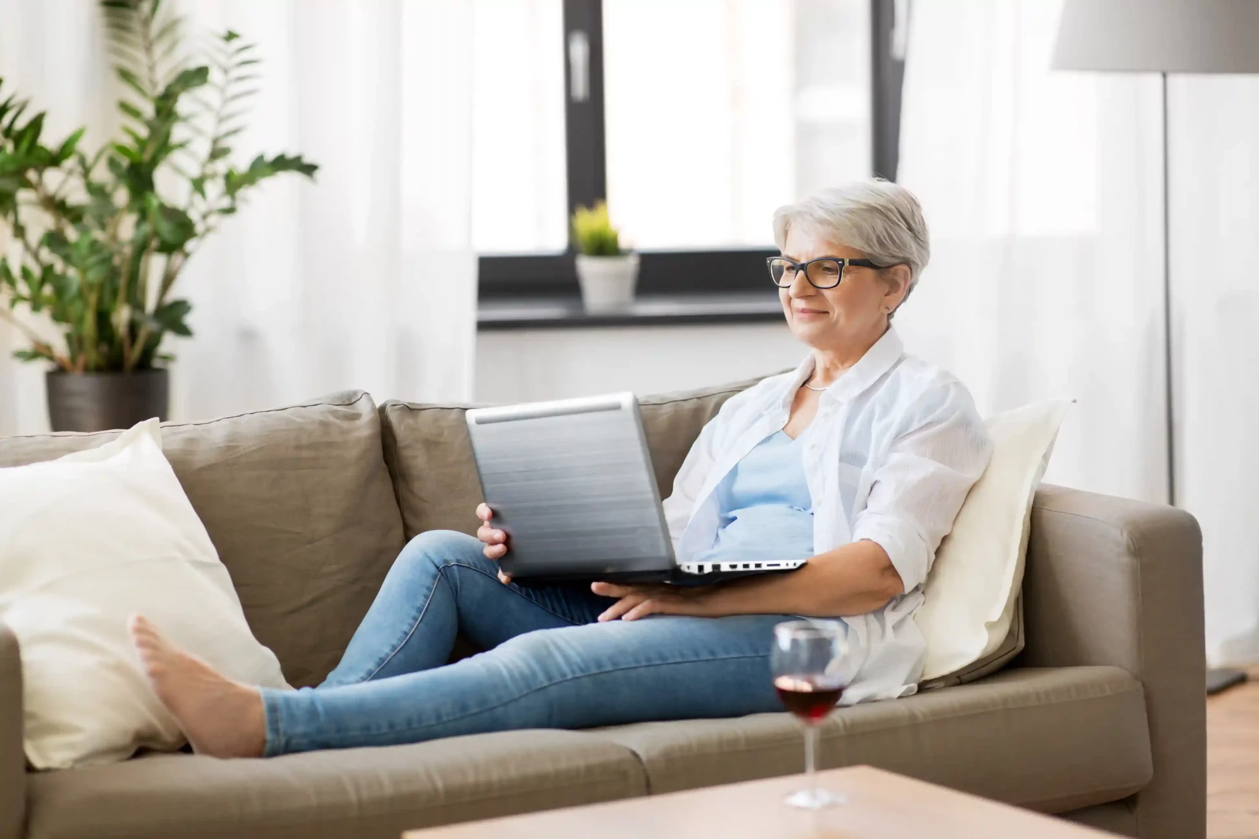 A user calmly checks her laptop from the couch, relying on Indosoft to clearly mark active conversations versus resolved ones so nothing is overlooked. A customer relaxes at home while reviewing messages on a laptop, confidently knowing Indosoft clearly shows which conversations are open and which have already been resolved.