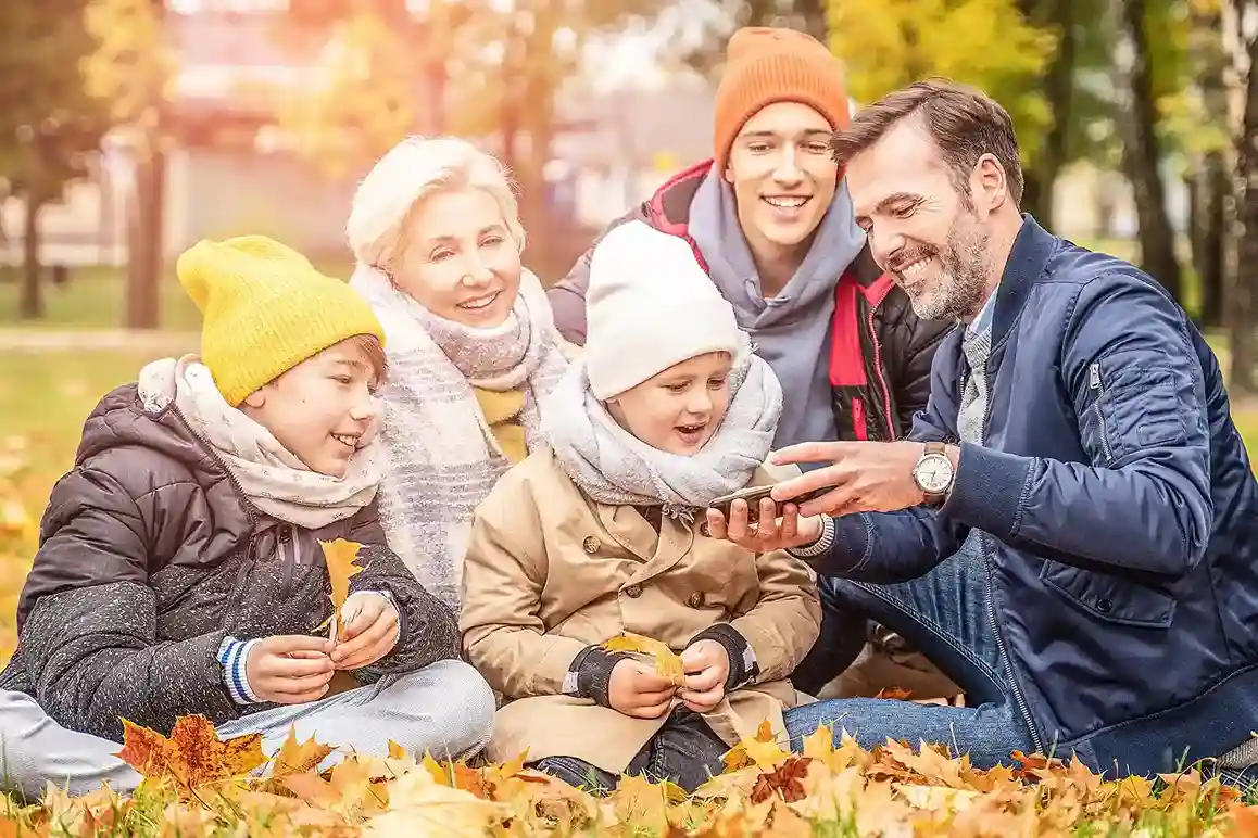 A family smiles while confirming vacation details as their call is smoothly transferred between travel specialists, showing how teamwork improves complex request handling. A family gathers around a phone while reviewing travel plans, reflecting how agents collaborate across departments through call transfers to provide accurate vacation details.