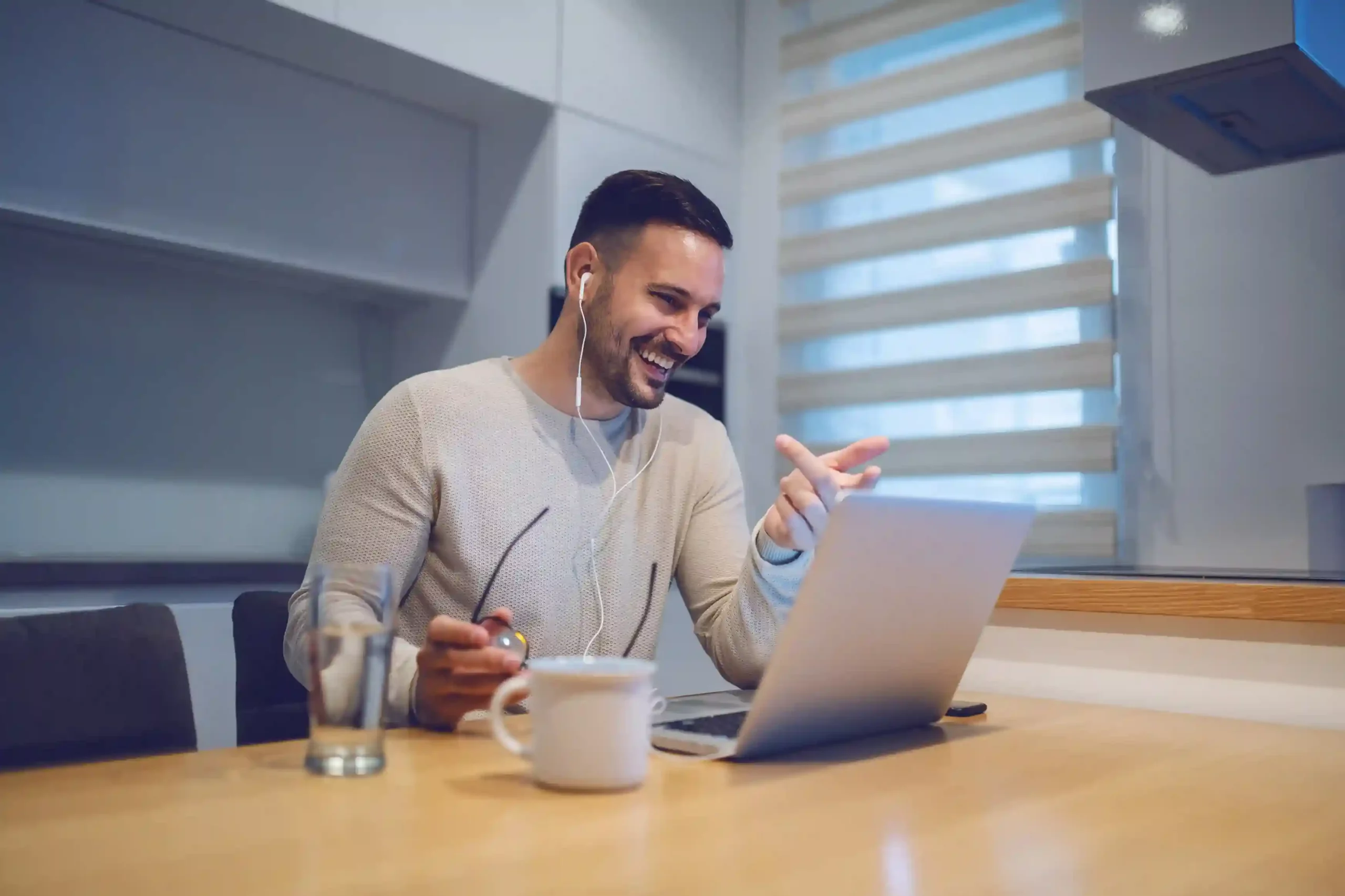 Smiling as he works, an agent checks a private message from a supervisor on his screen, showing how discreet assistance happens during live interactions. While engaged in a live interaction on his laptop, an agent receives quiet guidance from a supervisor through private chat, allowing the conversation to continue smoothly.