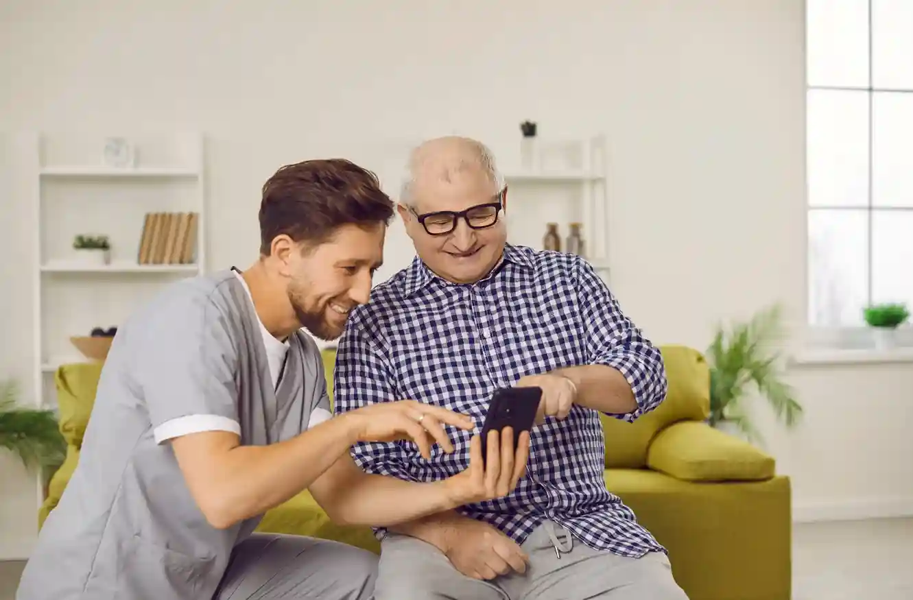 A caregiver assisting an elderly patient while secure call controls protect communication channels. A healthcare professional helping a senior citizen while Indosoft ensures blocked calls cannot reach the system.