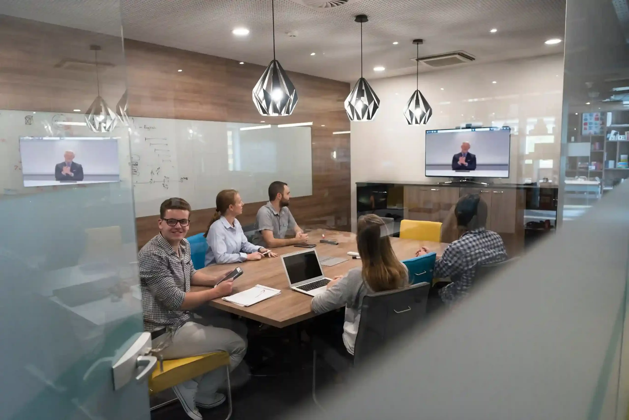 Several specialists sit around a table engaged in a shared discussion, demonstrating how conference calling brings expertise together to support the customer on one call. A group of team members gathers in a conference room while listening to a live call, showing customers that multiple experts are collaborating to resolve their needs together.