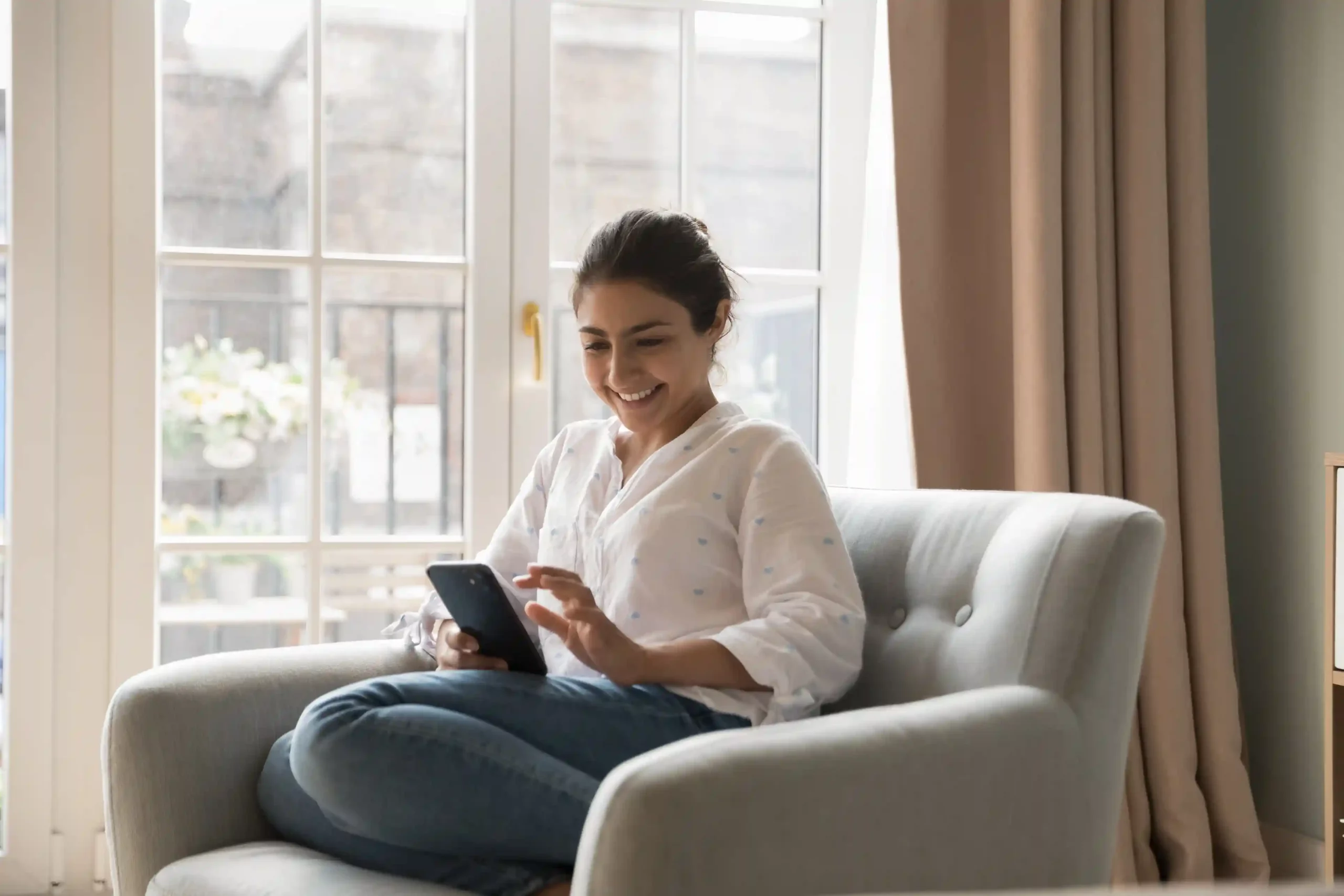 A professional relaxes at home while using her phone to reach the right person immediately, showing how call extensions reduce transfers by connecting callers correctly on the first try. A professional relaxes at home while using her phone to reach the right person immediately, showing how call extensions reduce transfers by connecting callers correctly on the first try.