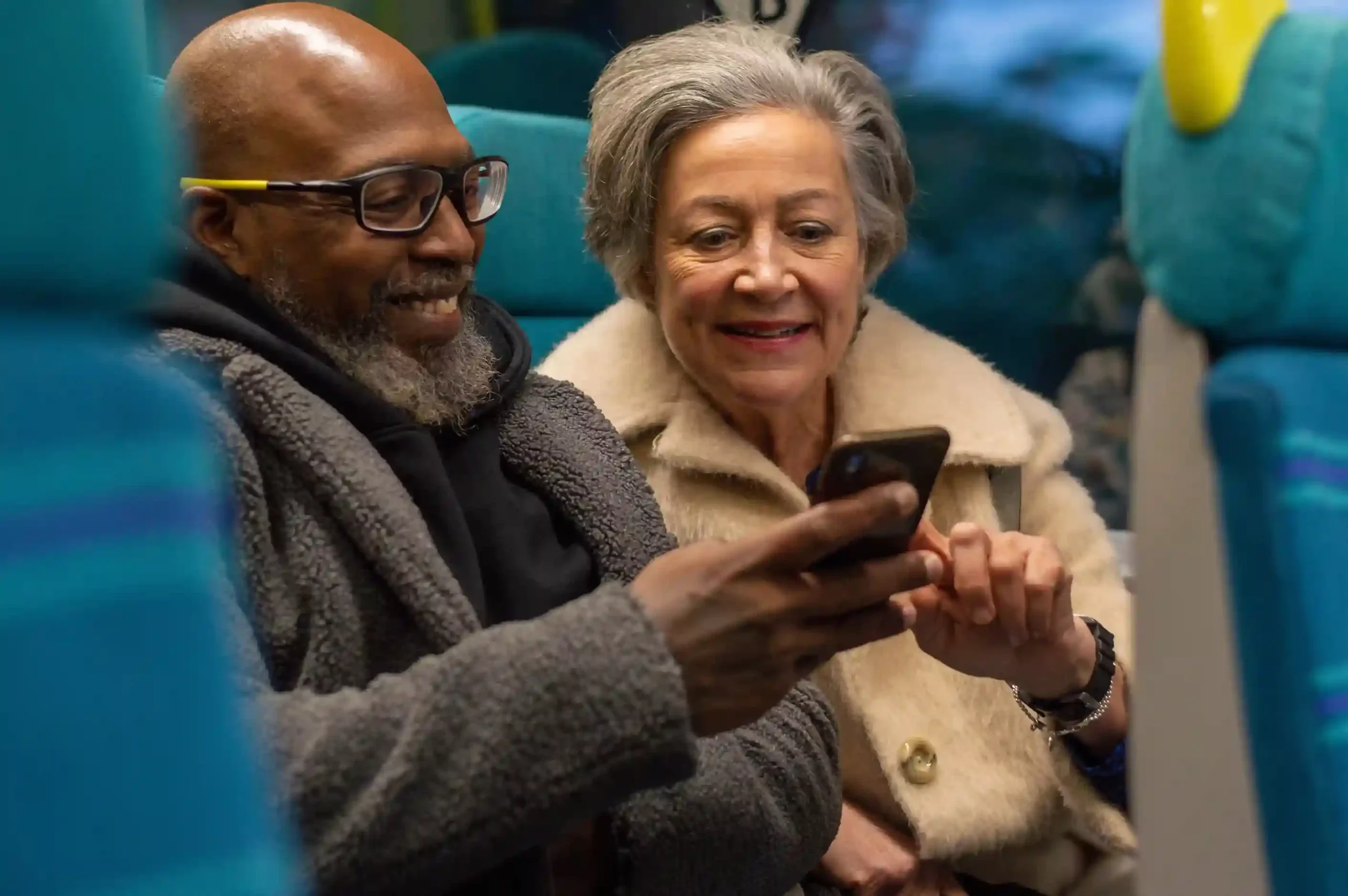 A couple follows clear on-screen prompts during a call, completing their inquiry through tailored IVR menus instead of waiting for live assistance. Two customers review options on a smartphone while traveling, successfully navigating a structured IVR flow that resolves their request without needing to speak to an agent.