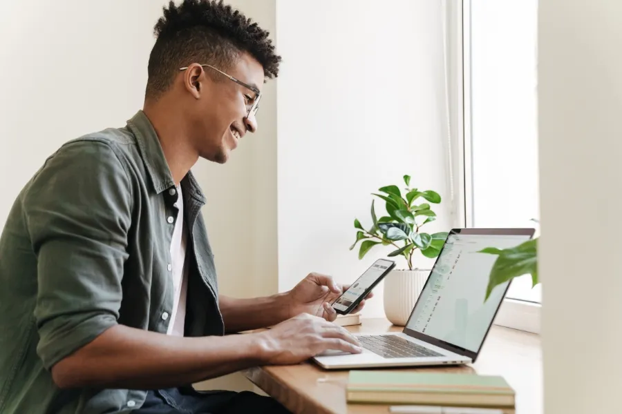 User enjoying a smooth workflow while Indosoft flags duplicates, missing fields, and invalid data issues. Happy user checking his laptop and phone as Indosoft detects duplicates and data errors automatically.