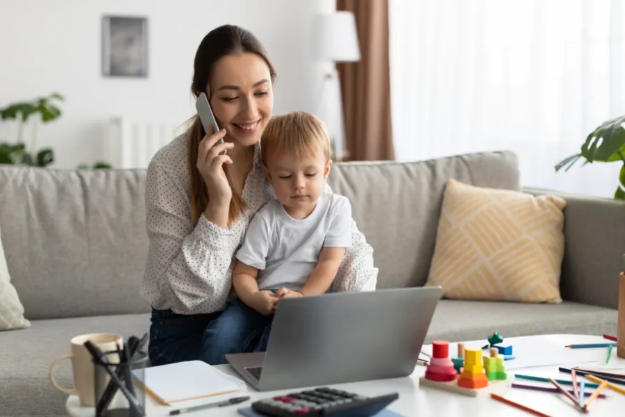 Indosoft interface helping a mother stay organized by grouping contacts into lists and segments. Mother working on a laptop with her child while Indosoft organizes her contact lists and segments.