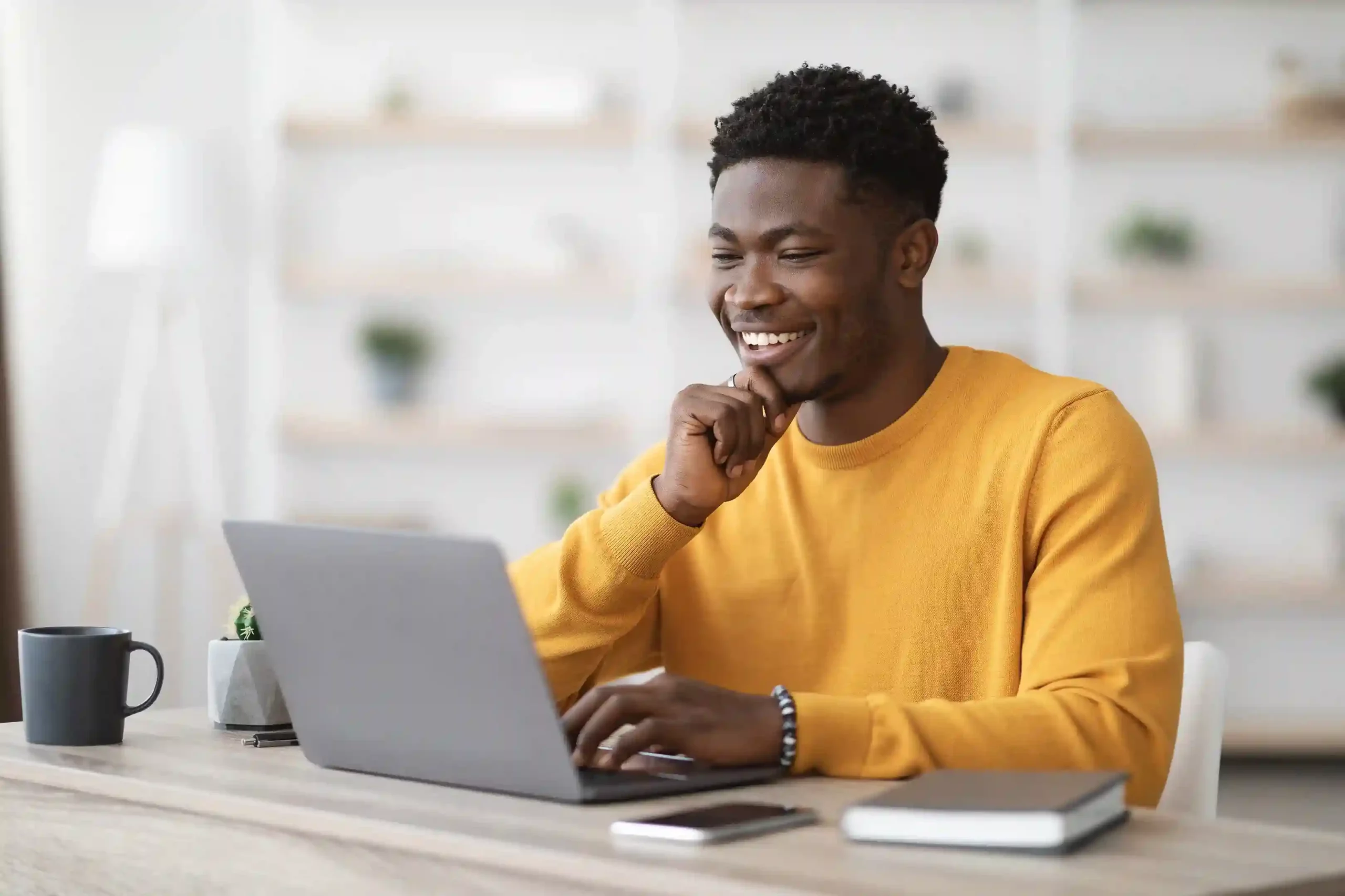 A professional checks key customer information on his screen, using organized contact records to stay informed as conversations happen. An agent smiles while reviewing customer details on his laptop, quickly understanding the full context of a conversation before reaching out.