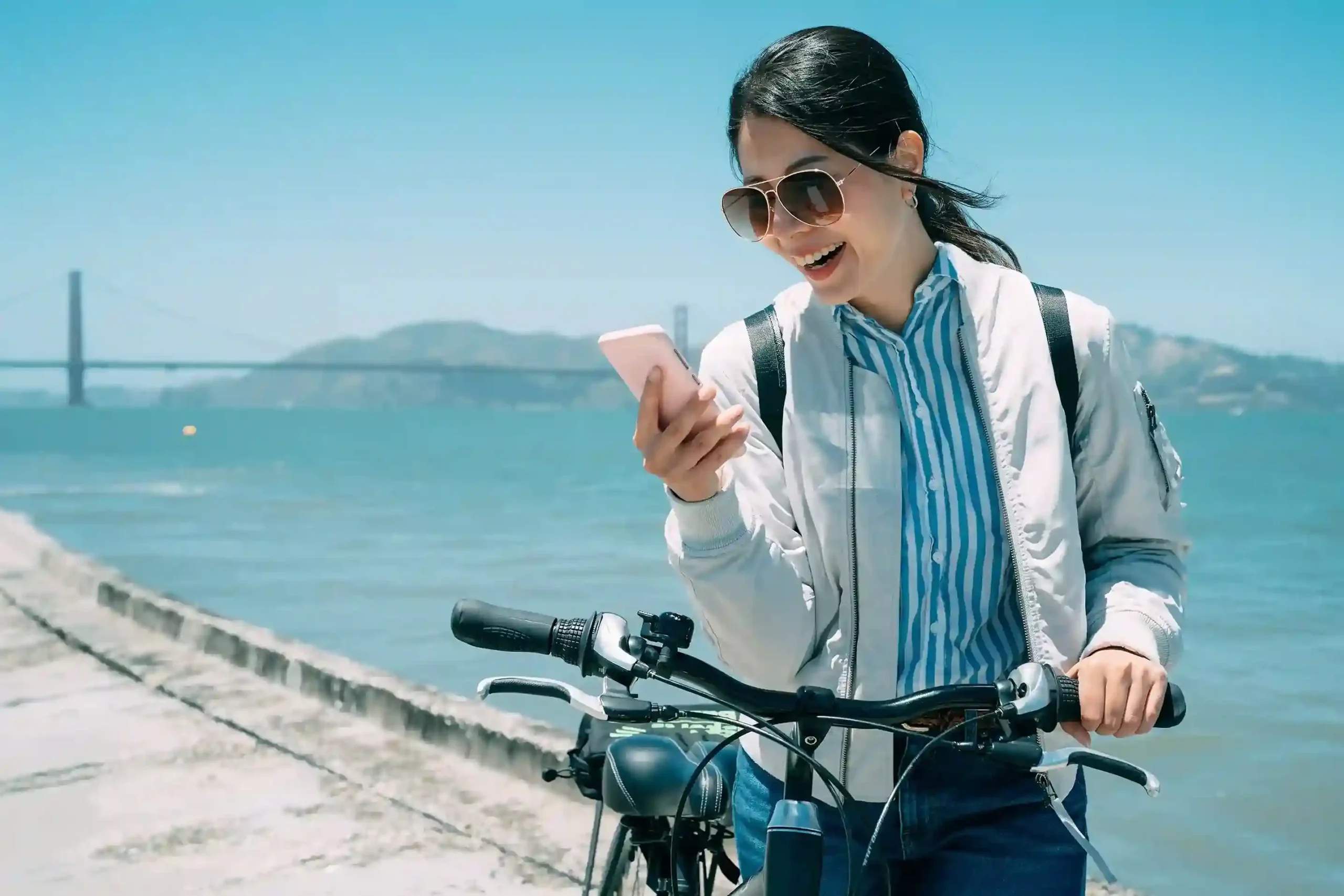 A professional on the move reviews a call on her mobile phone, relying on a centralized system to manage international communication smoothly and efficiently. A traveler pauses with her bicycle to check an international call on her phone, confidently staying connected through a single platform that manages global communication effortlessly.