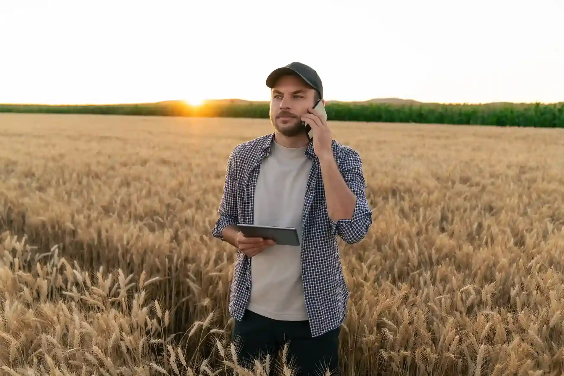 A business owner takes an international call from his farmland, using a trusted international number to stay connected with customers beyond national borders. A business supervisor stands in his agricultural field while speaking with clients on his phone, using international numbers to support expanding operations into new global markets.