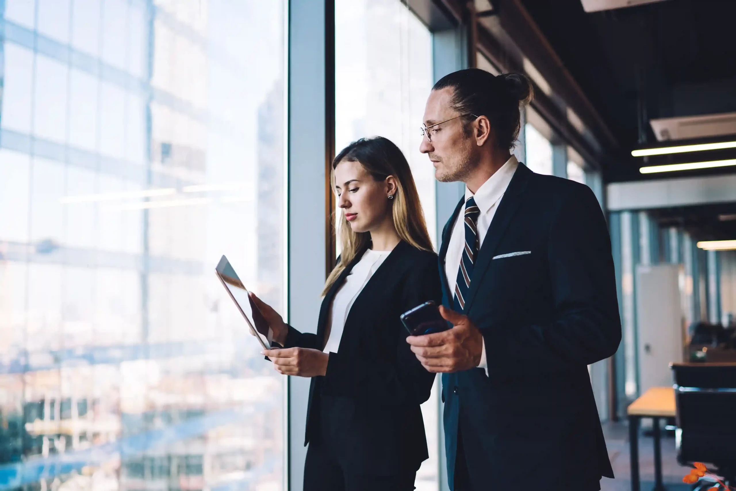 Attorney evaluates case success metrics on-screen using Indosoft’s data-driven solution for smarter legal decision-making. Legal professionals reviewing client and case performance data on a tablet and mobile device using Indosoft analytics