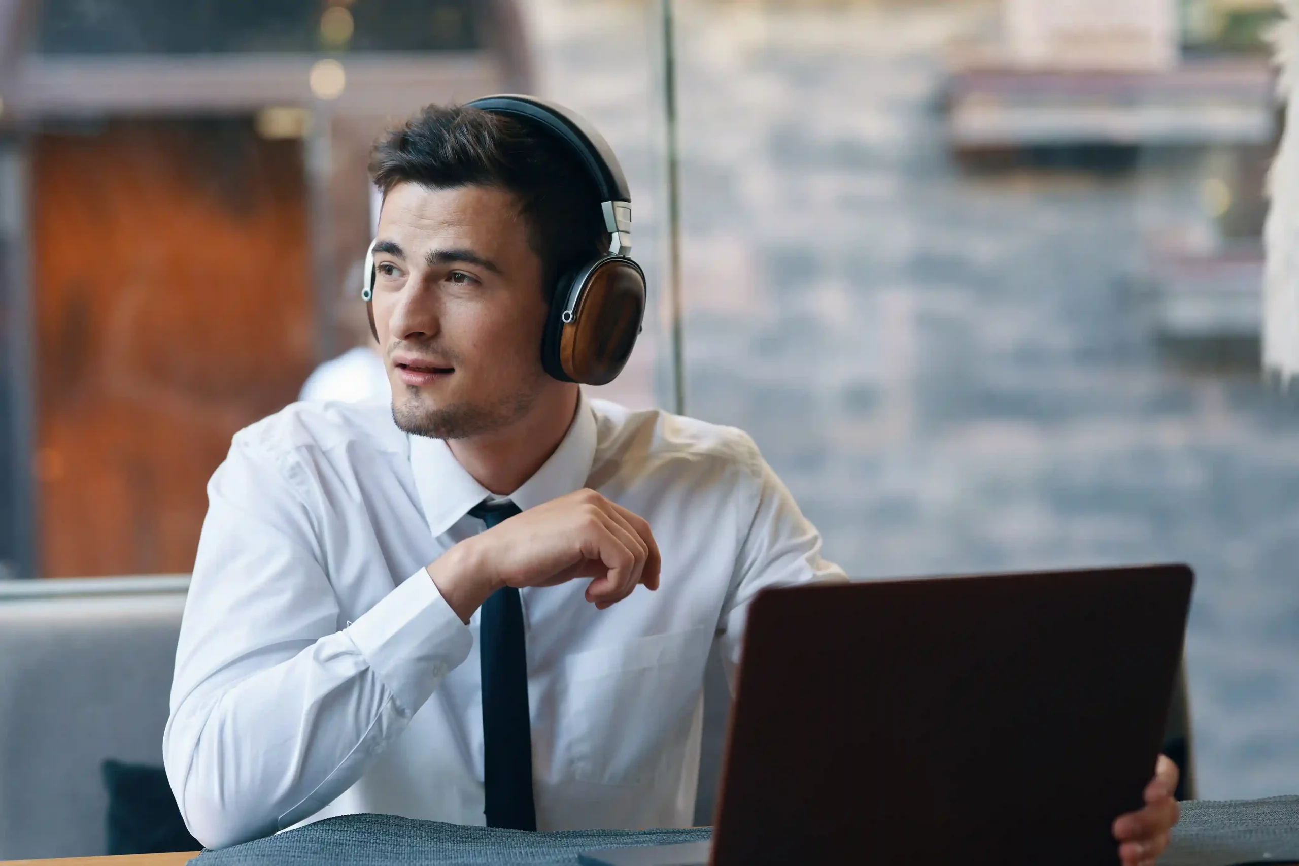 An agent prepares to assist a customer while automated IVR menus handle basic requests, allowing Indosoft to send only priority calls to human support. A contact center agent listens calmly through a headset while reviewing information on his laptop, handling only relevant calls after routine inquiries are filtered by Indosoft’s multi-level IVR.