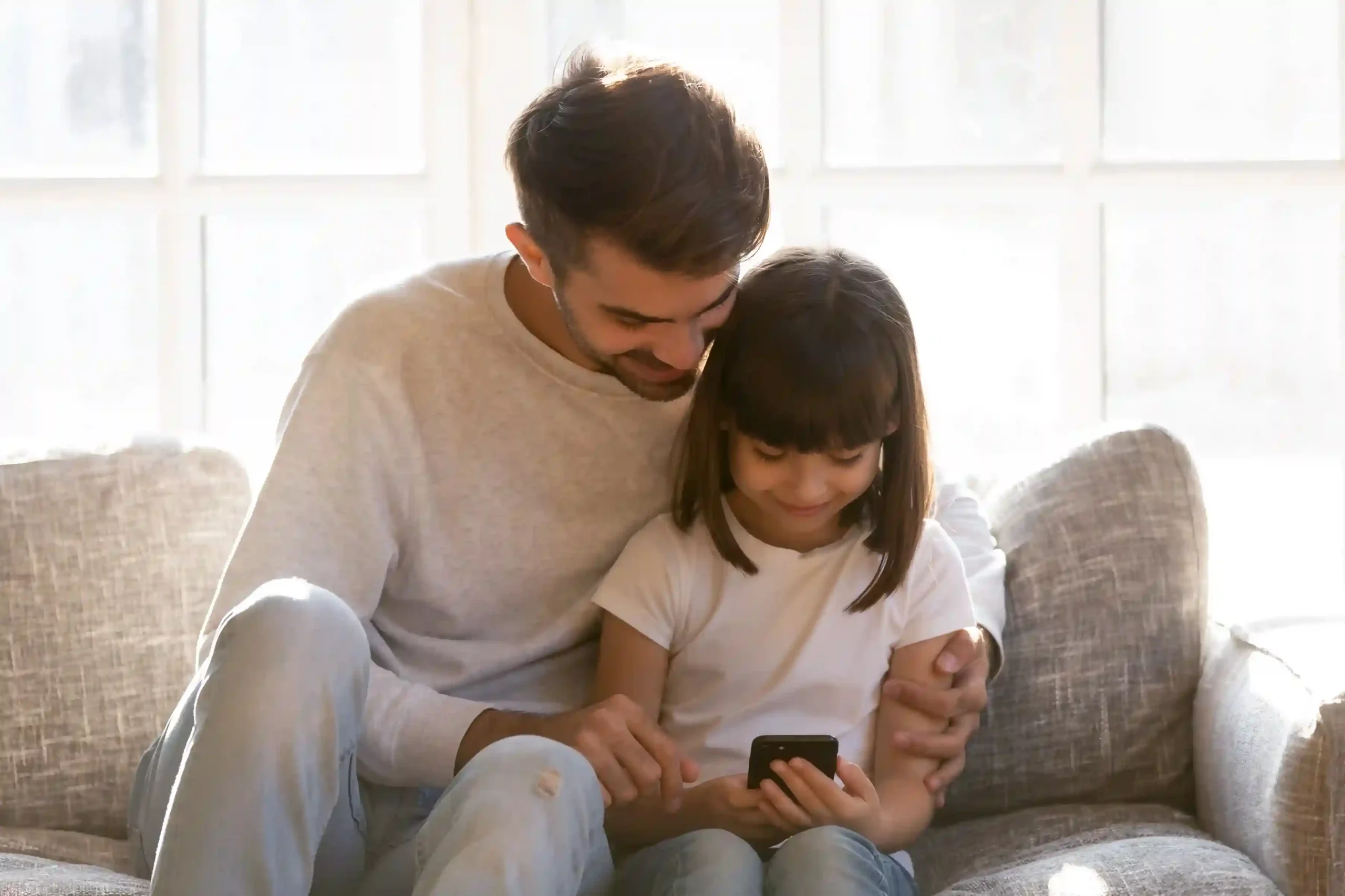 A parent teaches a child how to place a call using Indosoft’s call masking, ensuring phone numbers remain hidden and secure. A parent gently guides a child while making a phone call, showing how Indosoft’s call masking protects real phone numbers and keeps conversations private.
