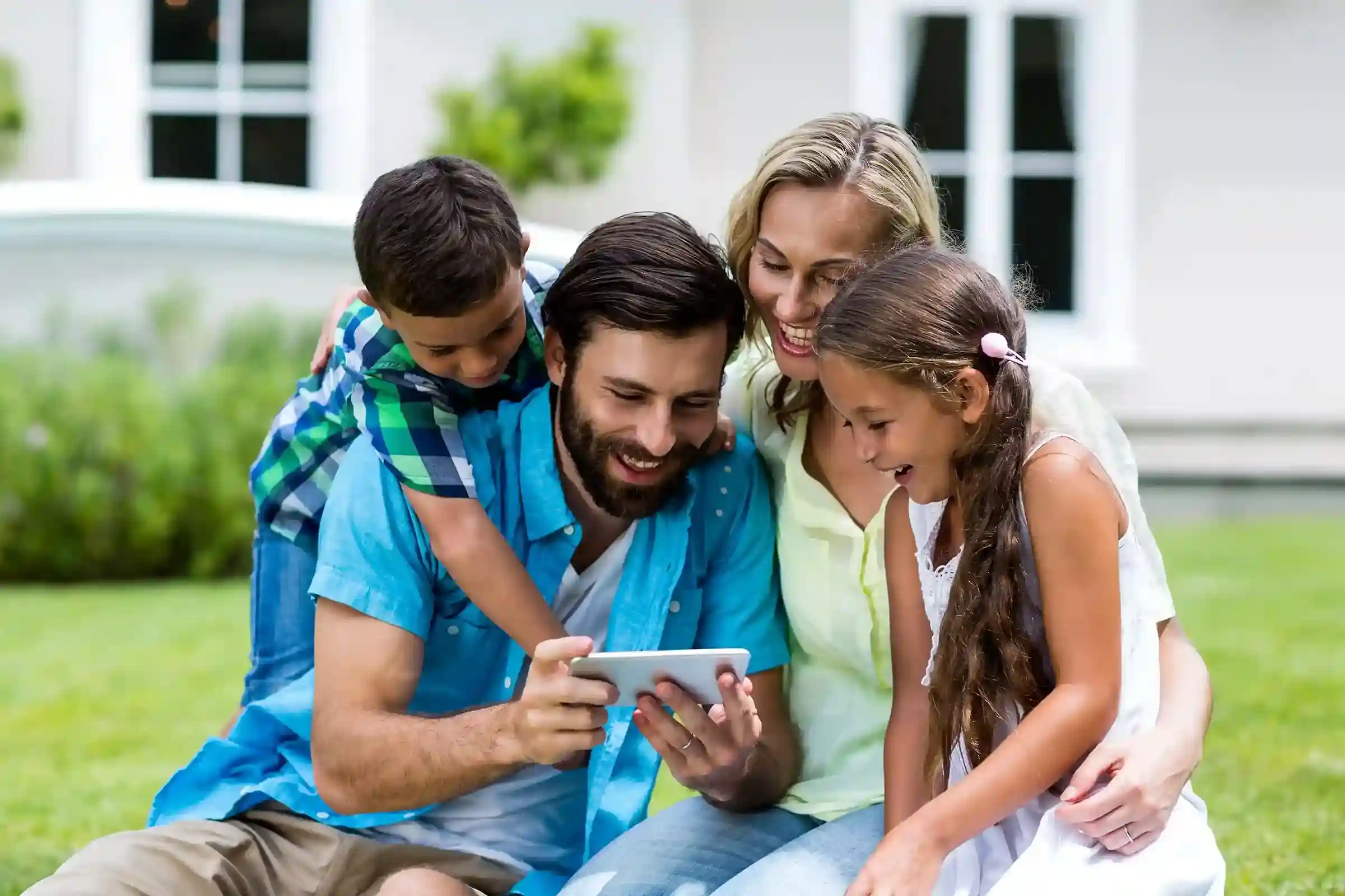 A family enjoys time together, representing the balance created by prioritizing and deprioritizing call types through call filters. A happy family gathers around a tablet, symbolizing how prioritized call filtering helps focus on the most important interactions.