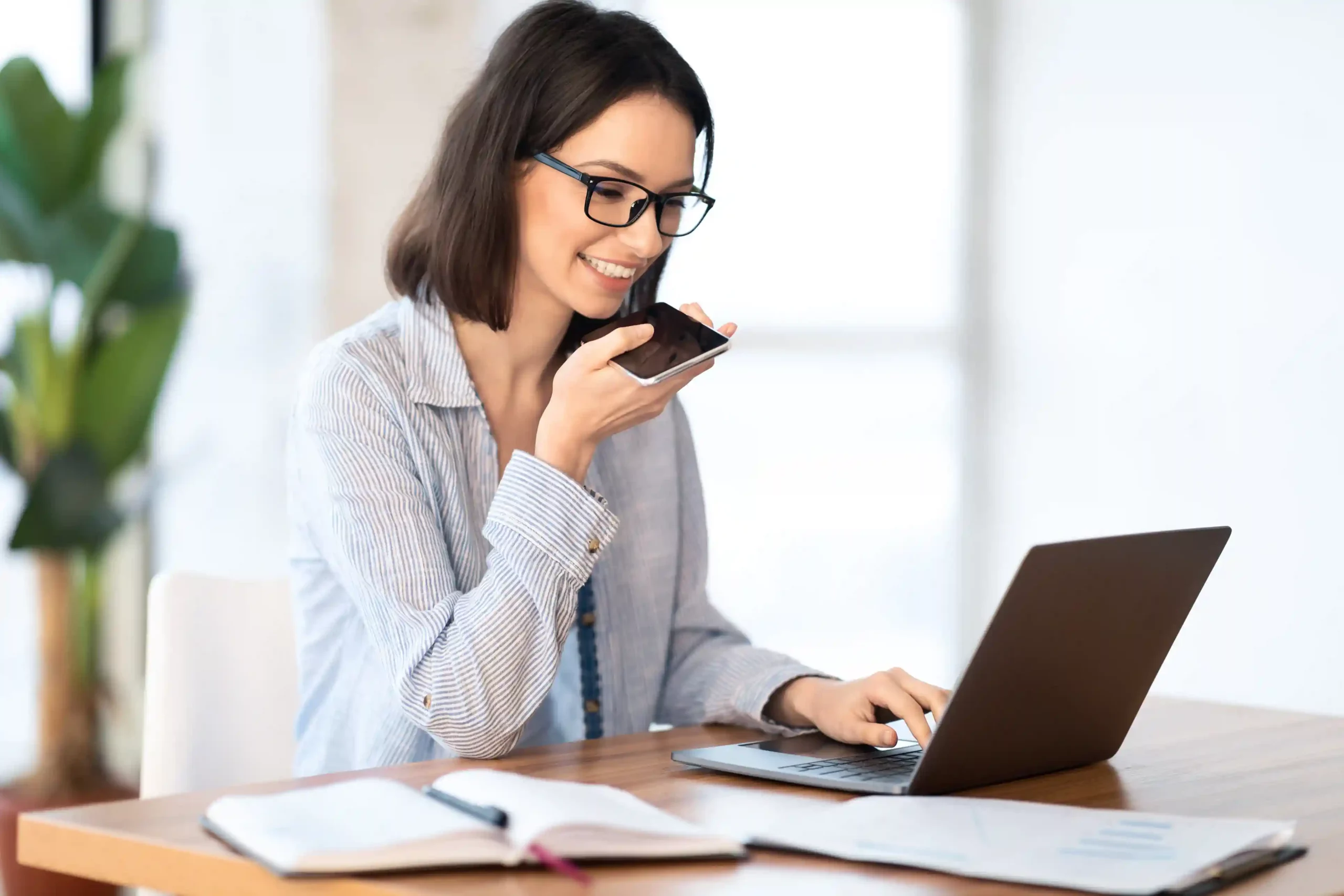 Balancing her work between a laptop and phone, an employee sends out messages knowing that shortcode-based delivery will remain stable even as message volume increases. While reviewing notes on her laptop, a professional records a message on her phone, trusting that Indosoft Shortcodes will deliver SMS notifications consistently even during busy messaging periods.