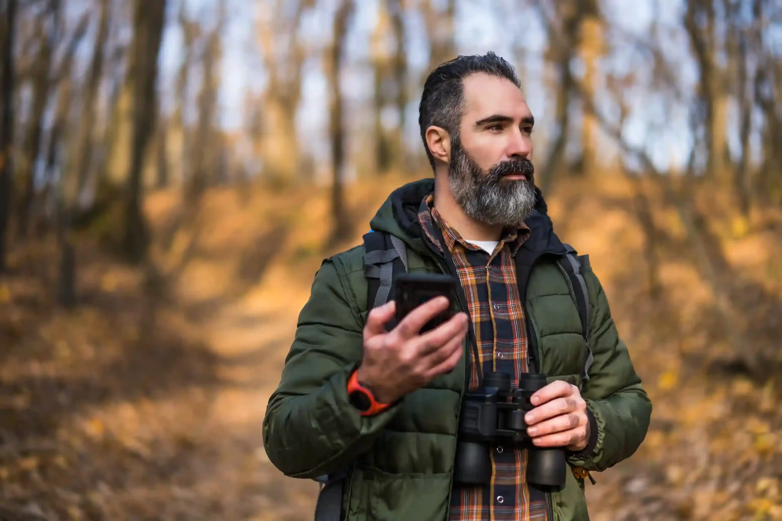 A traveler checks his phone in a wooded area as his call is seamlessly transferred to navigation support, helping him get precise directions when it matters most. A traveler pauses on a forest trail to place a call, relying on a transferred conversation to reach the navigation team and get clear directions without delay.