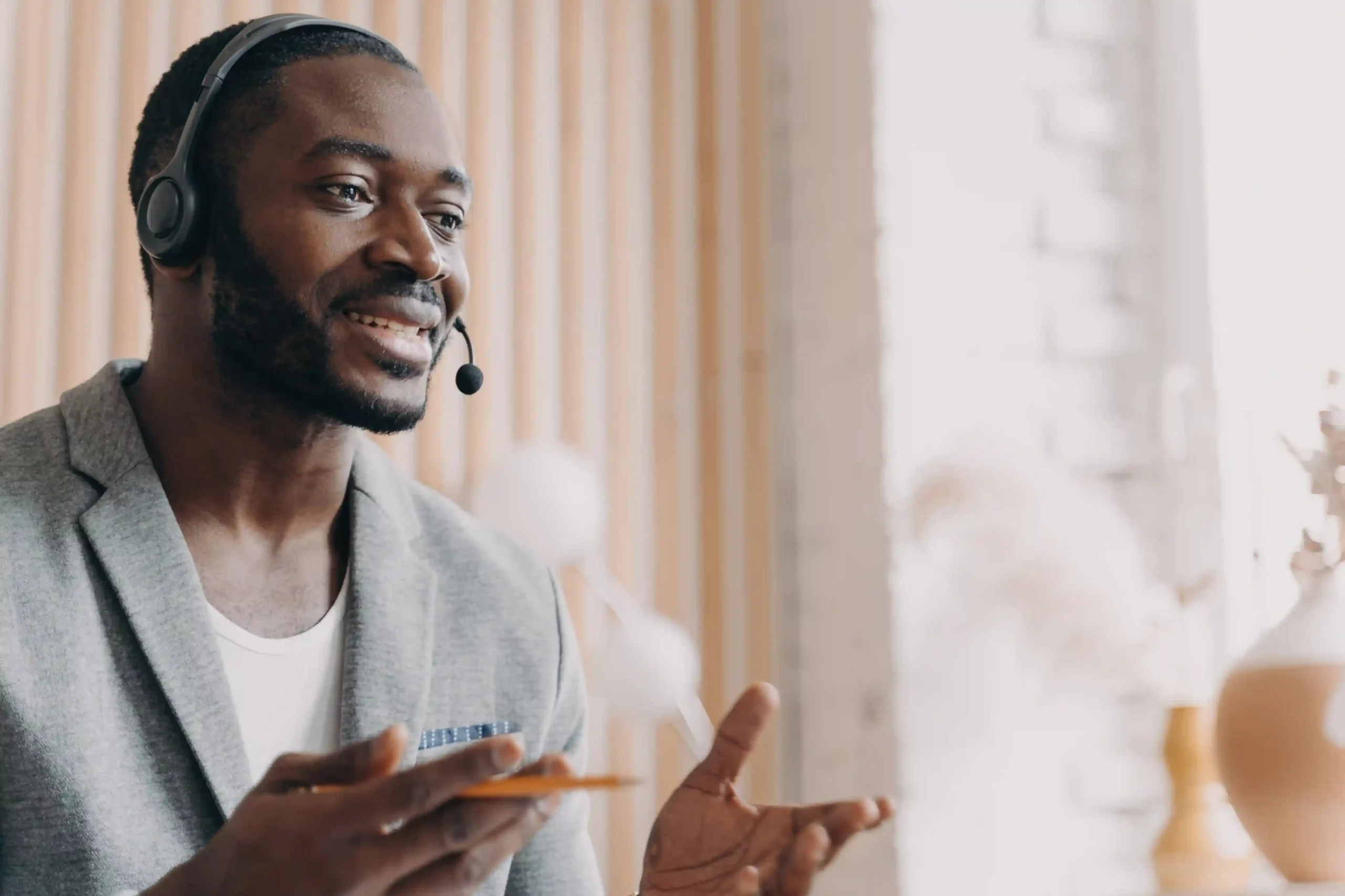 Mid-conversation, an agent confidently engages with a caller after responding instantly through a nearby device, reflecting how Ring All Devices minimizes response delays Wearing a headset, a contact center agent responds immediately to an incoming call, showing how Ring All Devices helps him answer from the closest available device without delay.