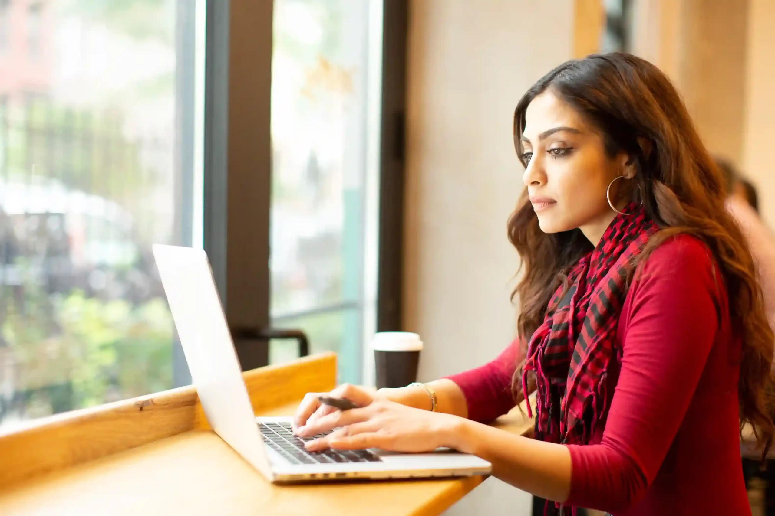 Focused on system setup, an admin fine-tunes call routing rules on her laptop so calls are automatically directed based on business priorities and caller data. An administrator reviews routing conditions on her laptop, configuring smart rules that decide where incoming calls should go before they ever reach a queue.