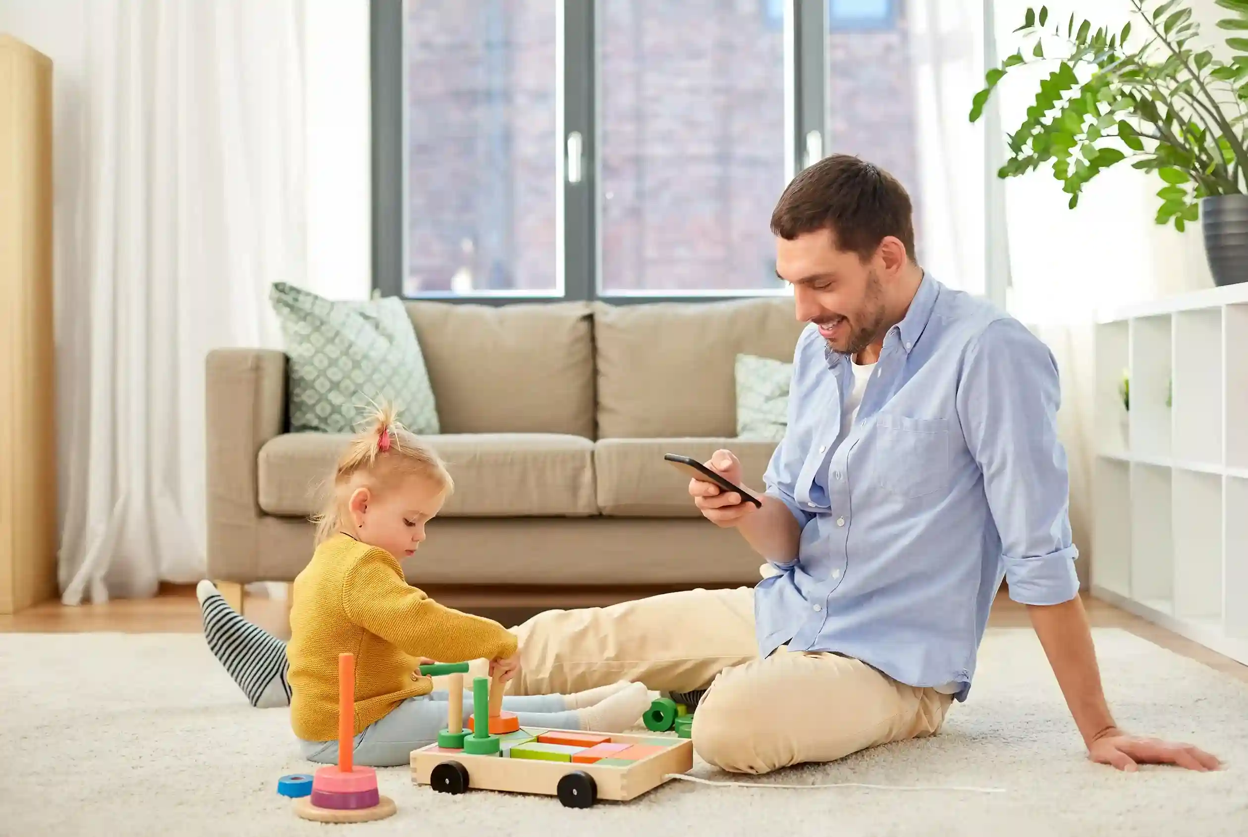 A parent enjoys a smooth phone conversation while caring for a child, reflecting how Indosoft enables seamless calls with masking applied invisibly. A parent calmly speaks on the phone while playing with a child, showing how Indosoft’s call masking keeps conversations natural without interrupting daily moments.
