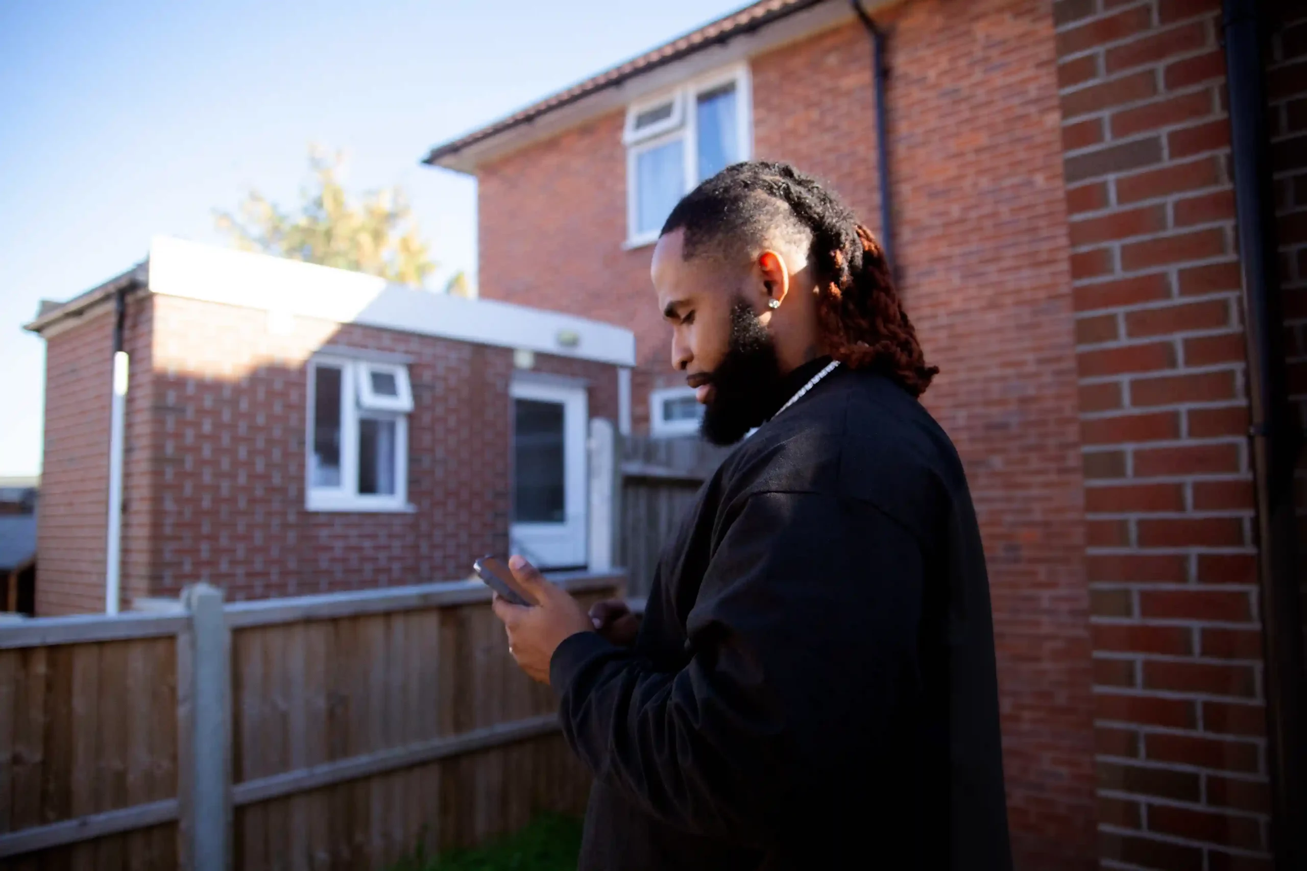 A business caller reviews a phone during an active conversation, reflecting how Indosoft records calls securely while keeping voice data encrypted and protected end to end. A professional checks a phone while making a business call outdoors, trusting that the conversation is being securely recorded and protected through encrypted voice capture.