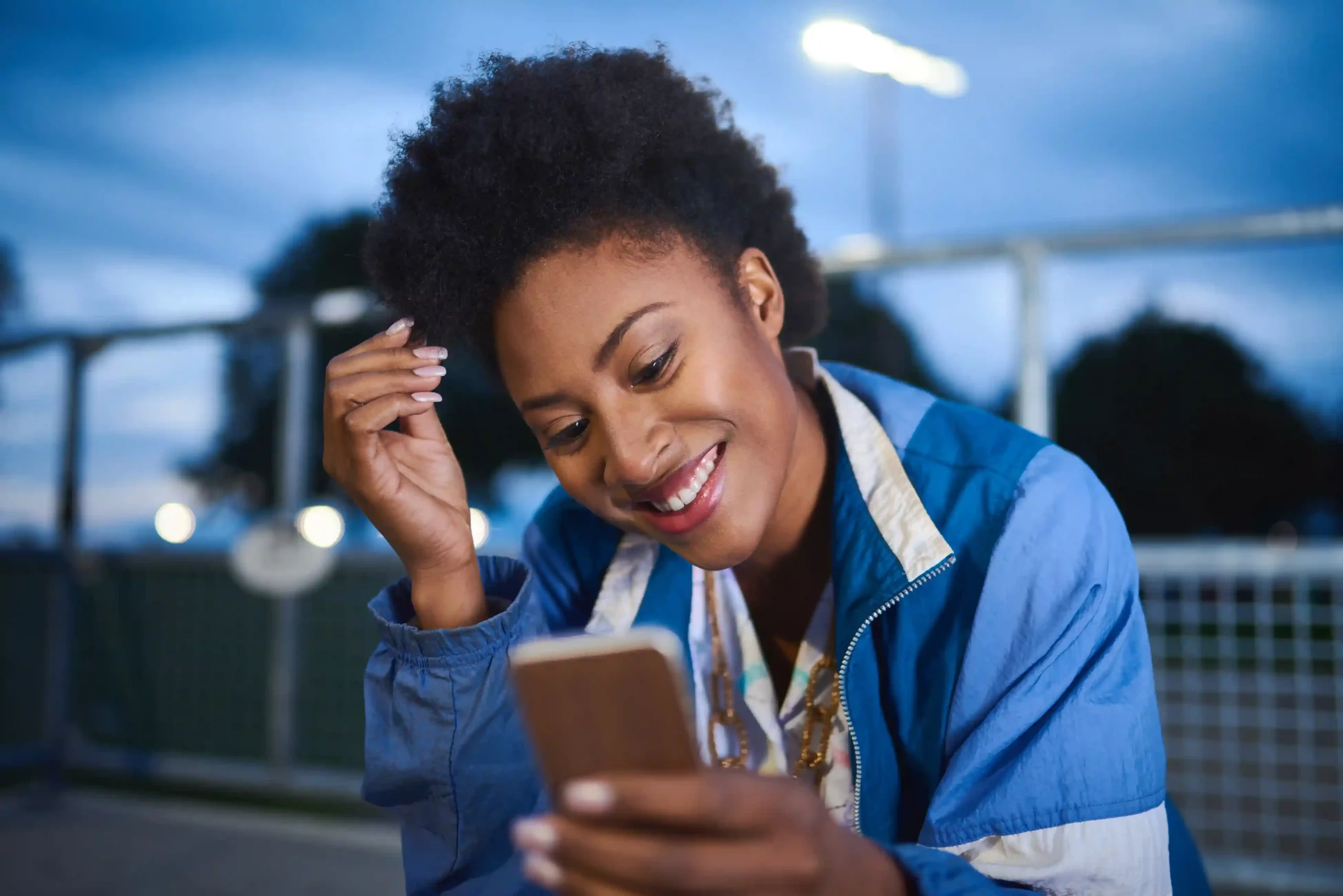 Reviewing a message on her phone, a customer completes a voice interaction that connects and disconnects cleanly, reflecting dependable SIP session handling within Indosoft. Smiling as she checks her phone outdoors, a customer experiences a smoothly connected voice session made reliable by consistent SIP call setup and teardown behind the scenes.