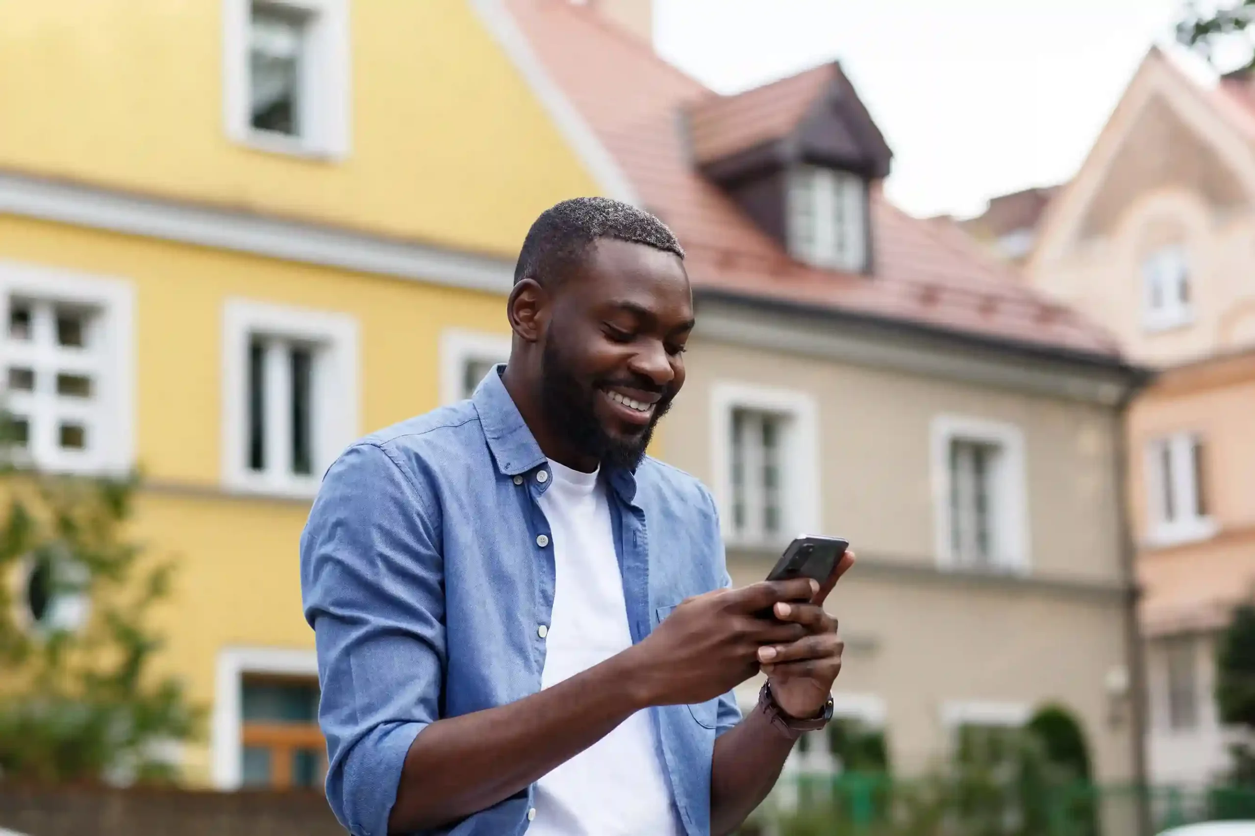 Standing outdoors, a man checks an important SMS without scrolling through clutter, reflecting how filtered messages help teams stay focused on priority interactions. A professional smiles while reviewing a single, relevant SMS on his phone, benefiting from message filters that surface only actionable customer conversations.