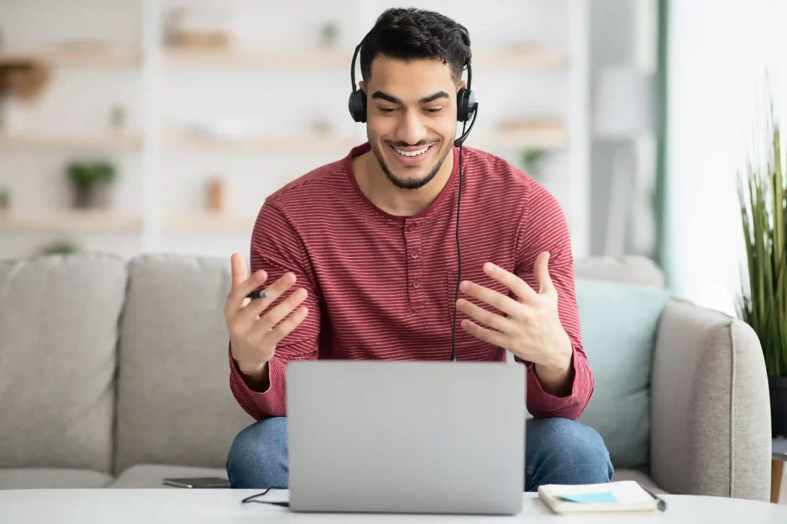 A remote agent wearing a headset smiles while updating call outcome labels on a laptop for consistent interaction tracking. A contact center agent wearing a headset reviews call outcomes on his laptop using standardized call labels for accurate reporting.