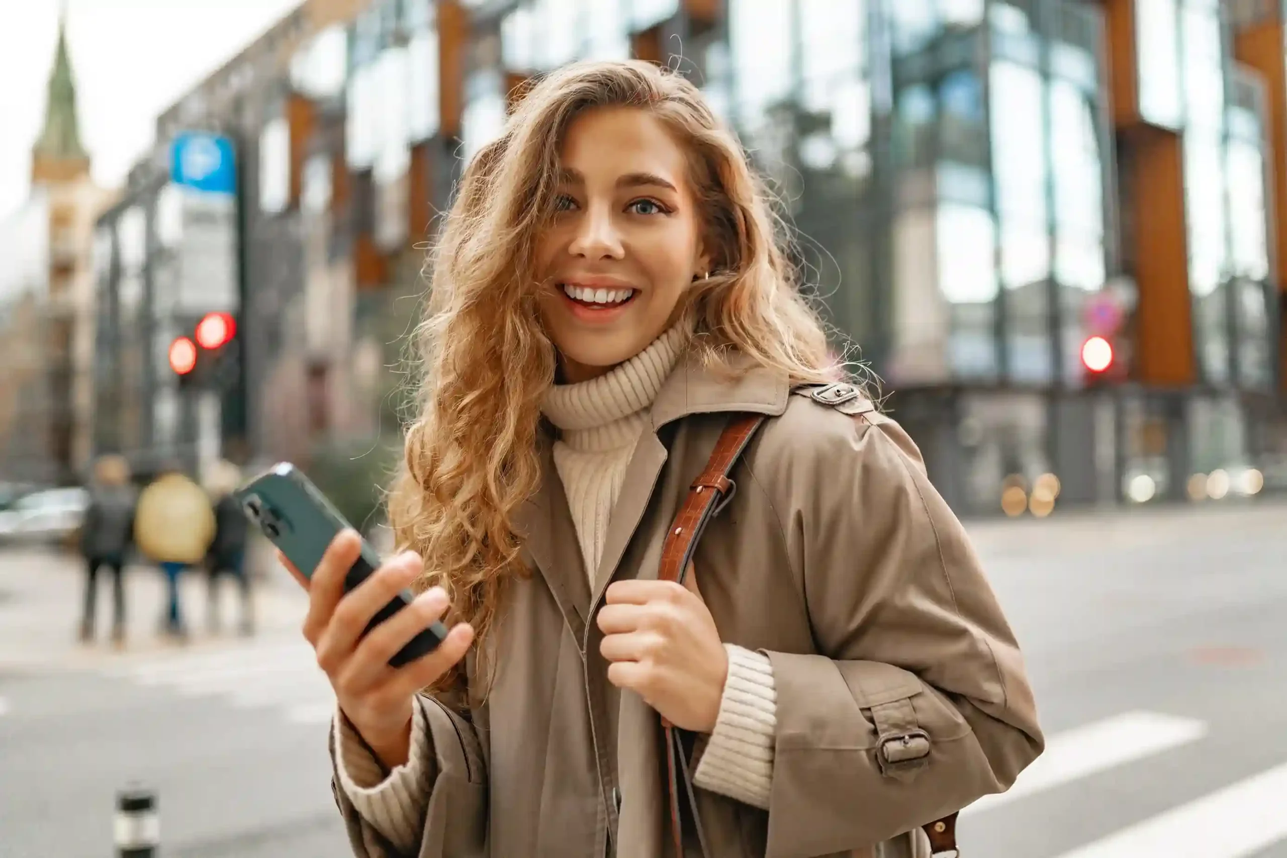 A customer-facing professional smiles as she triggers a call from her phone, demonstrating how click to call ensures precise outbound connections in real time. A professional woman confidently initiates a call from her mobile while on the move, relying on click to call to connect instantly without dialing errors.